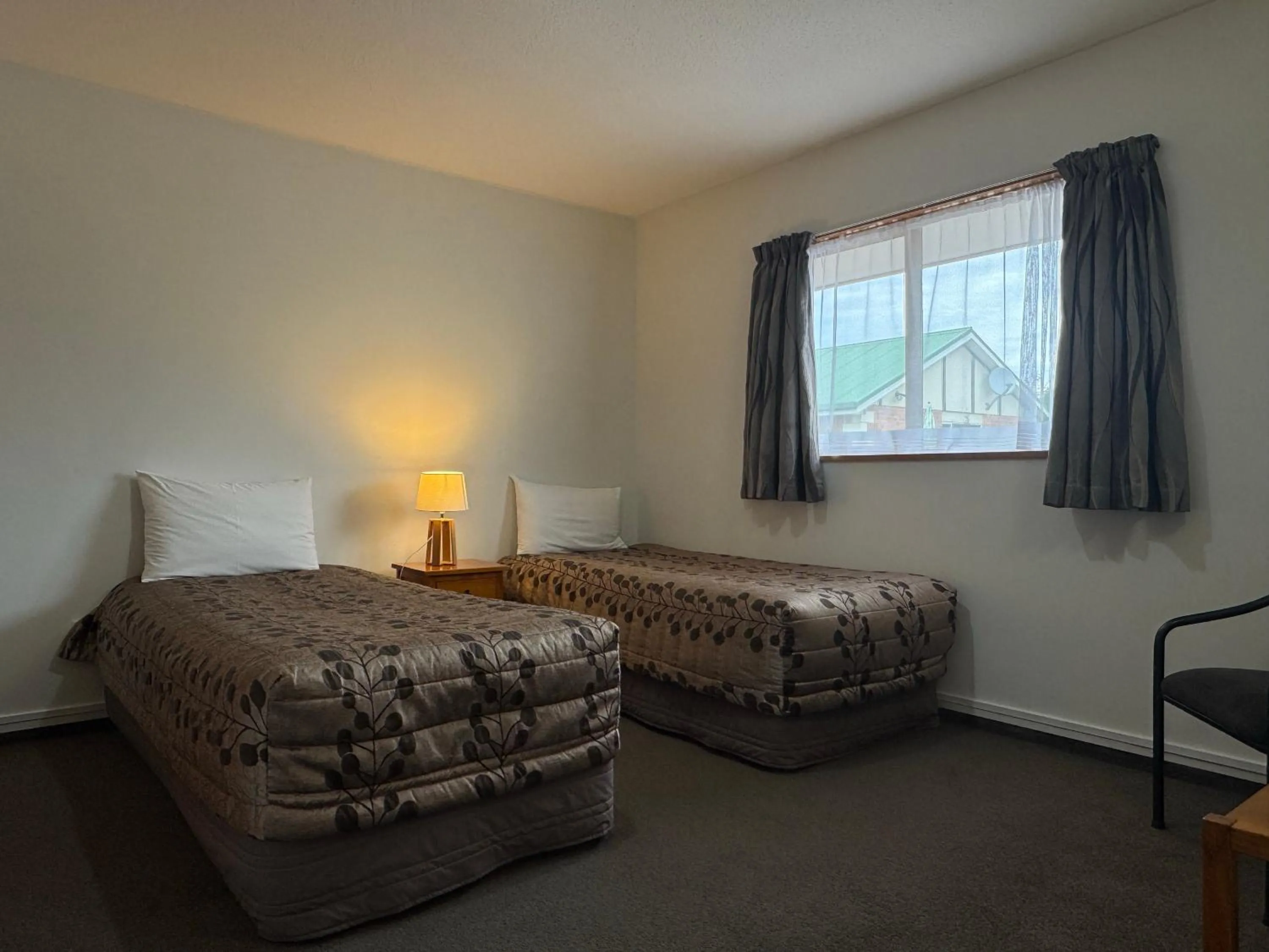 Bed in ASURE Ambassador Motor Lodge