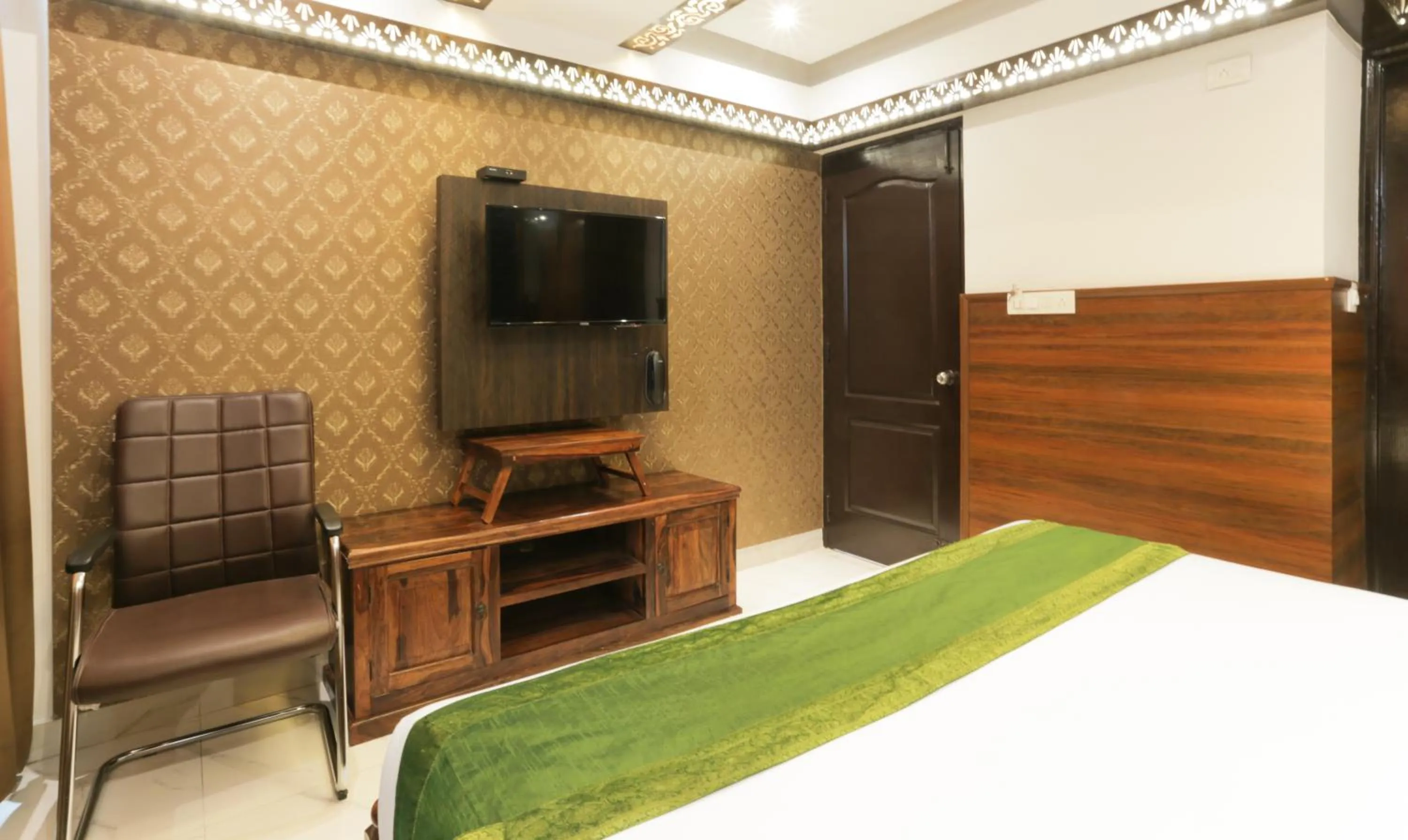 Communal lounge/ TV room, Bed in Hotel Dvaraka Inn
