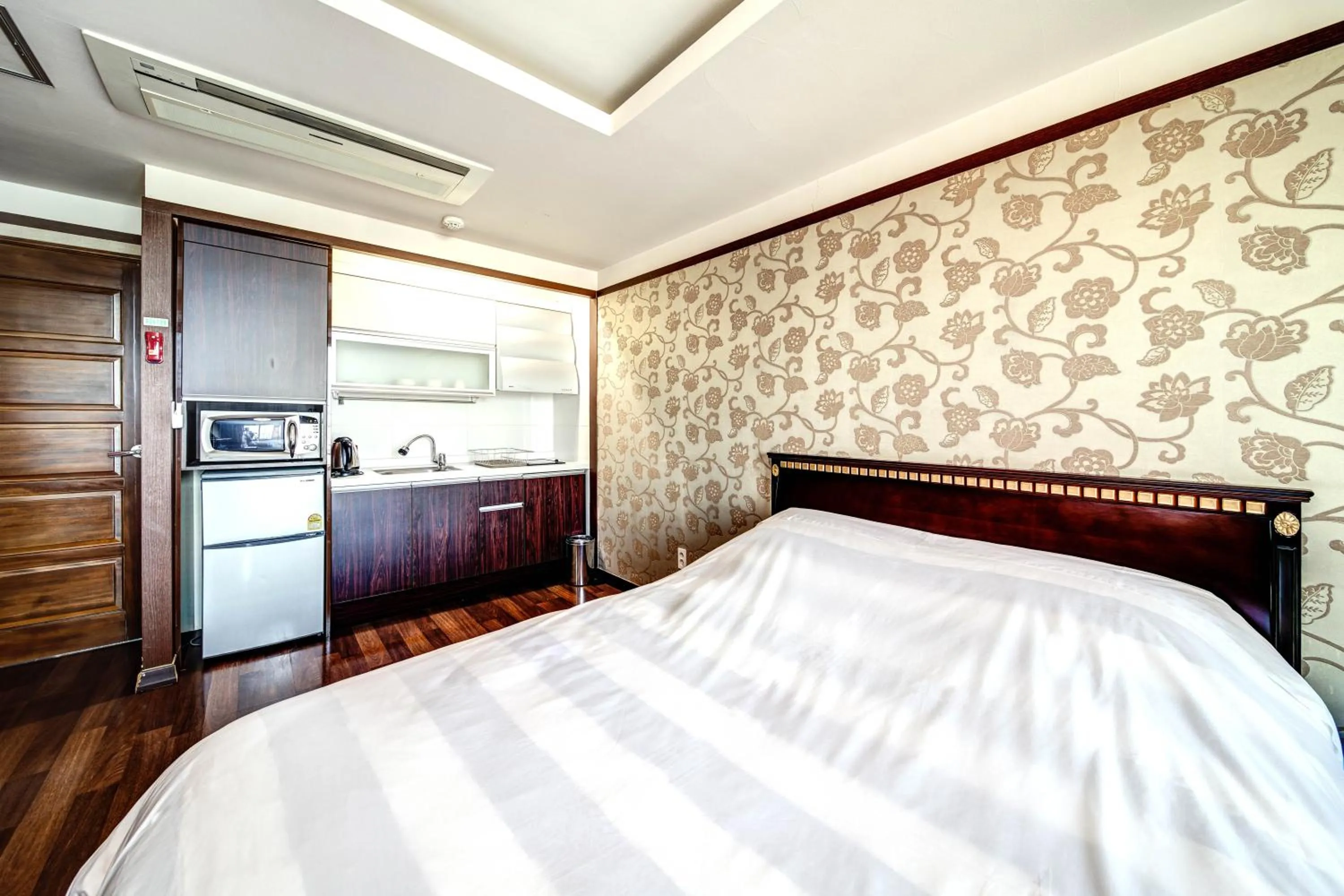 Kitchen or kitchenette, Bed in Geoje Oasis Hotel