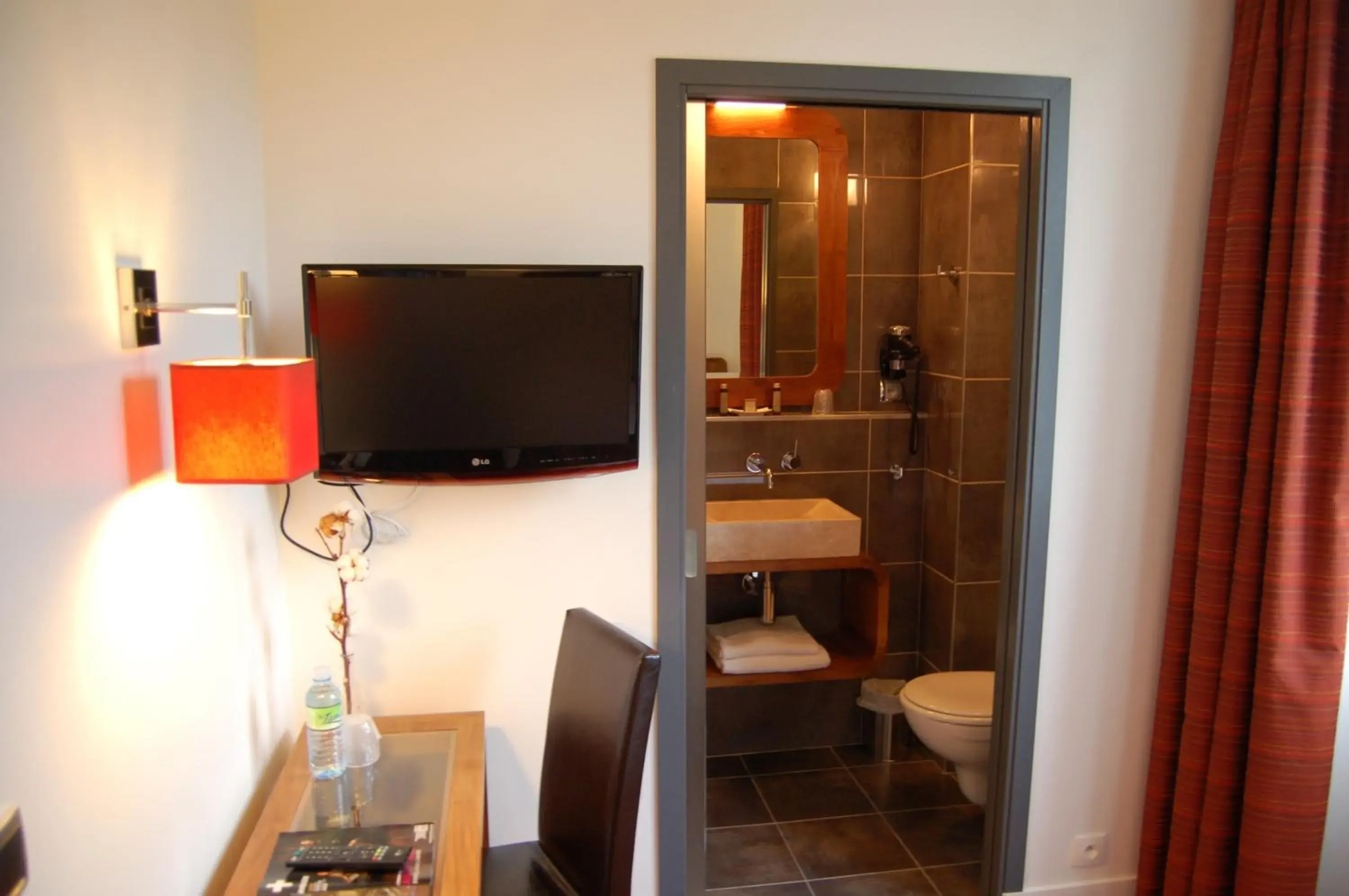 Bathroom, TV/Entertainment Center in Logis le Manoir de Sauvegrain