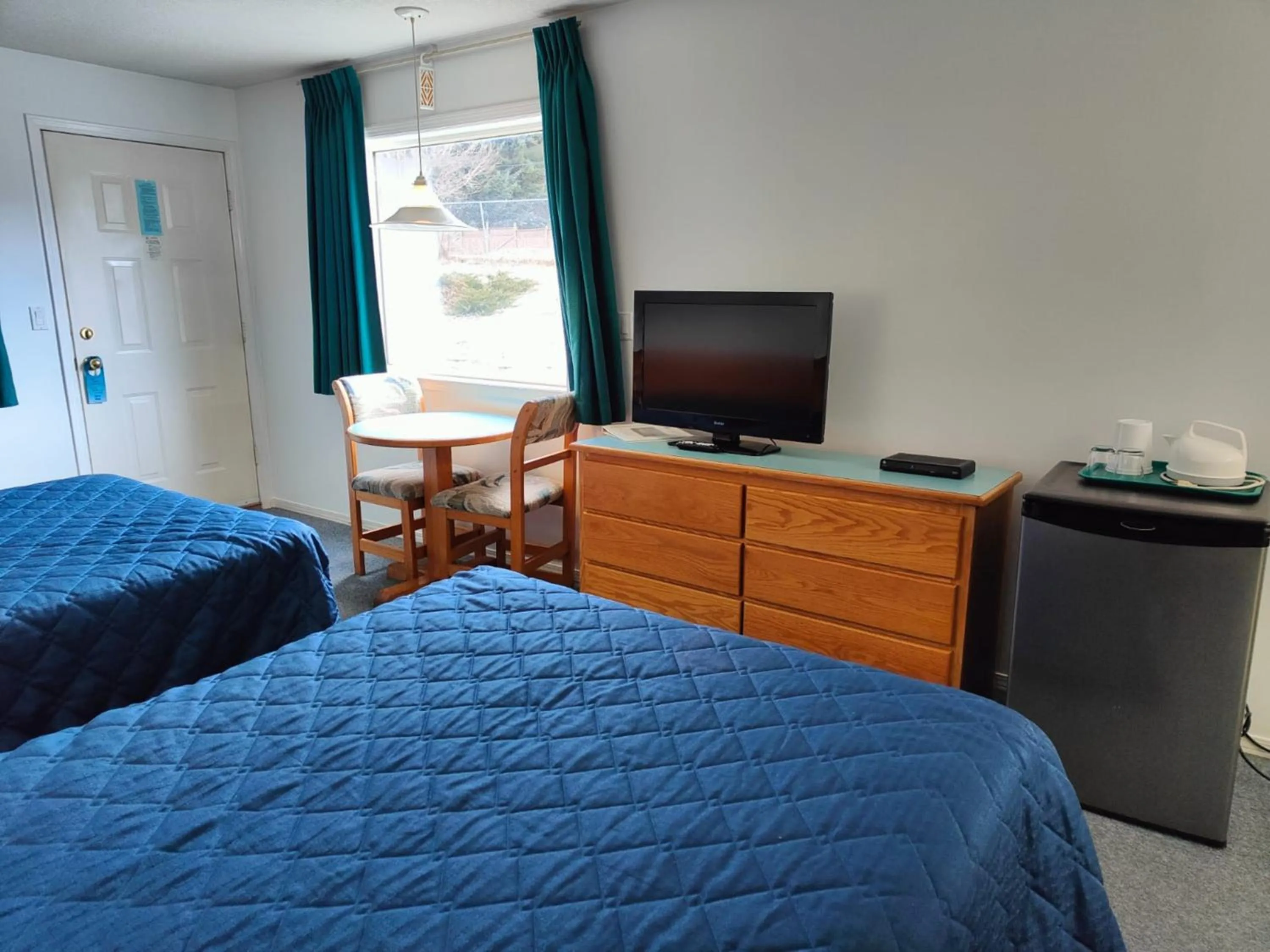 Communal lounge/ TV room, Bed in Ponderosa Motor Inn