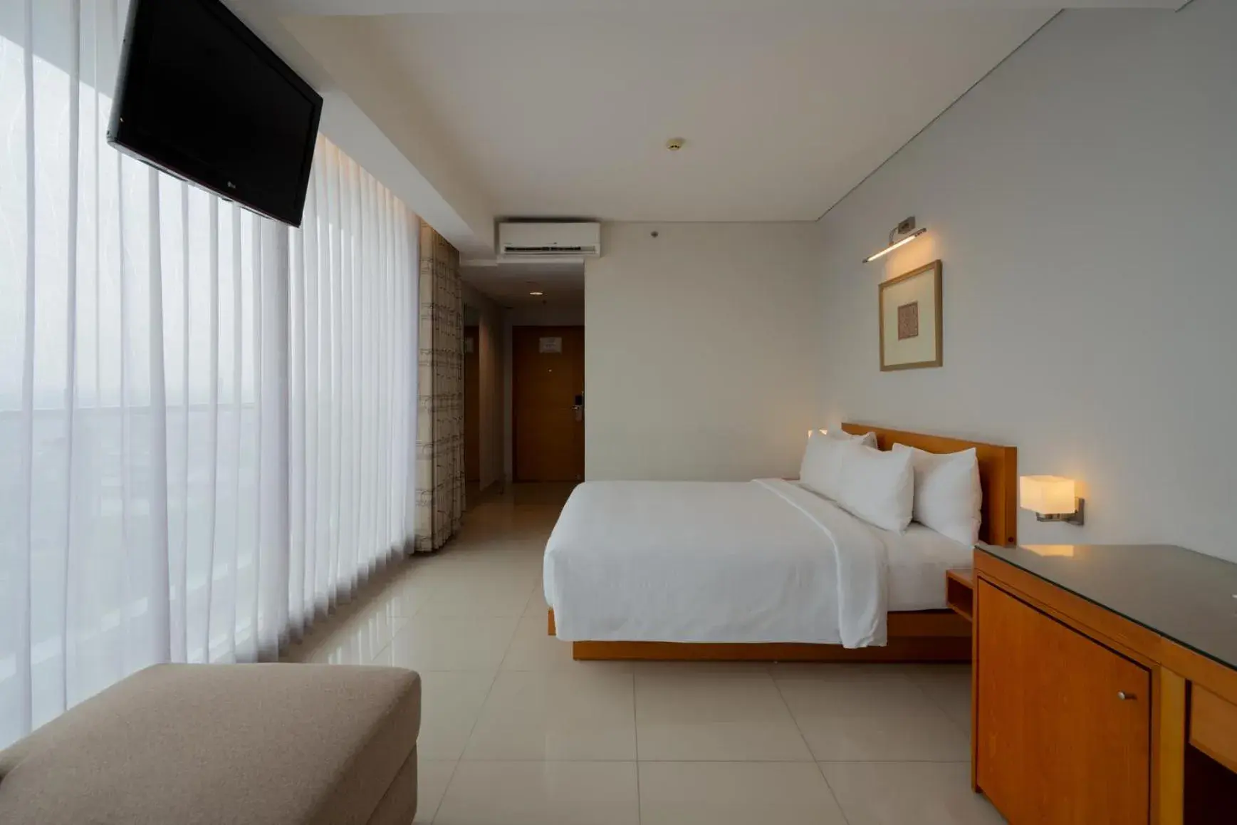 Communal lounge/ TV room, Bed in Hotel Santika Jemursari