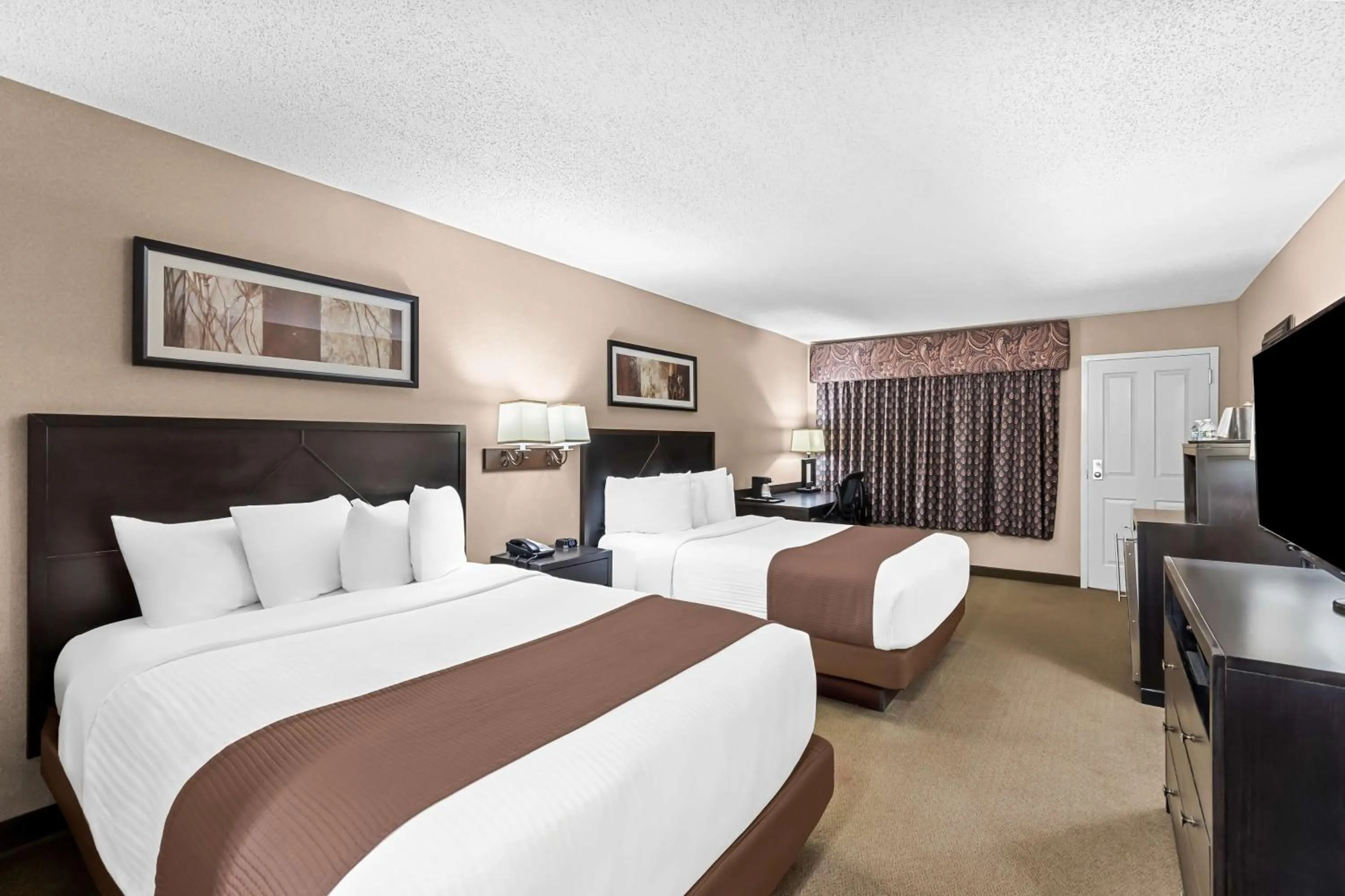 Bedroom, Bed in Heartland Inn & Suites, SureStay Collection by Best Western