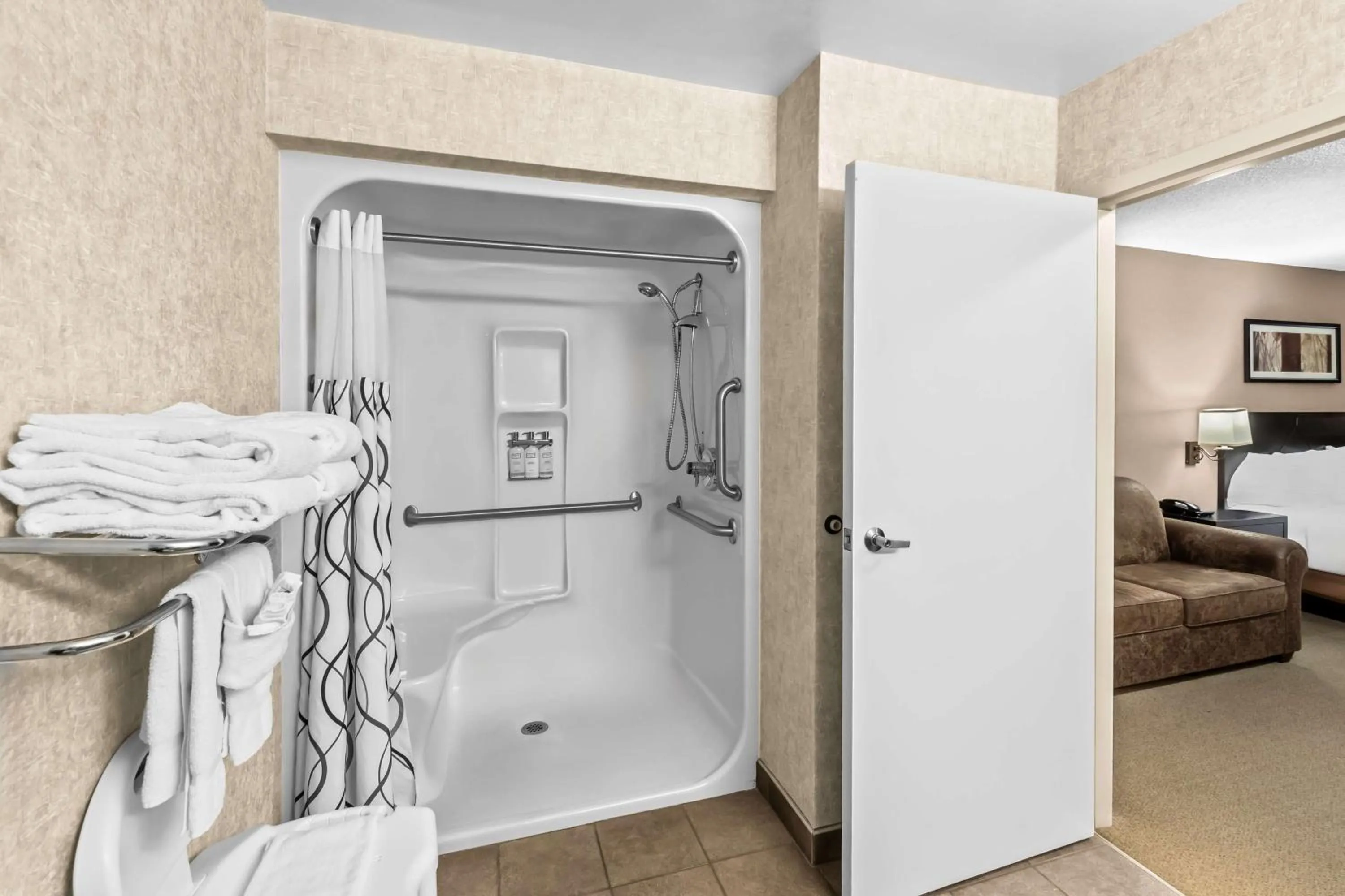 Bathroom, Bed in Heartland Inn & Suites, SureStay Collection by Best Western