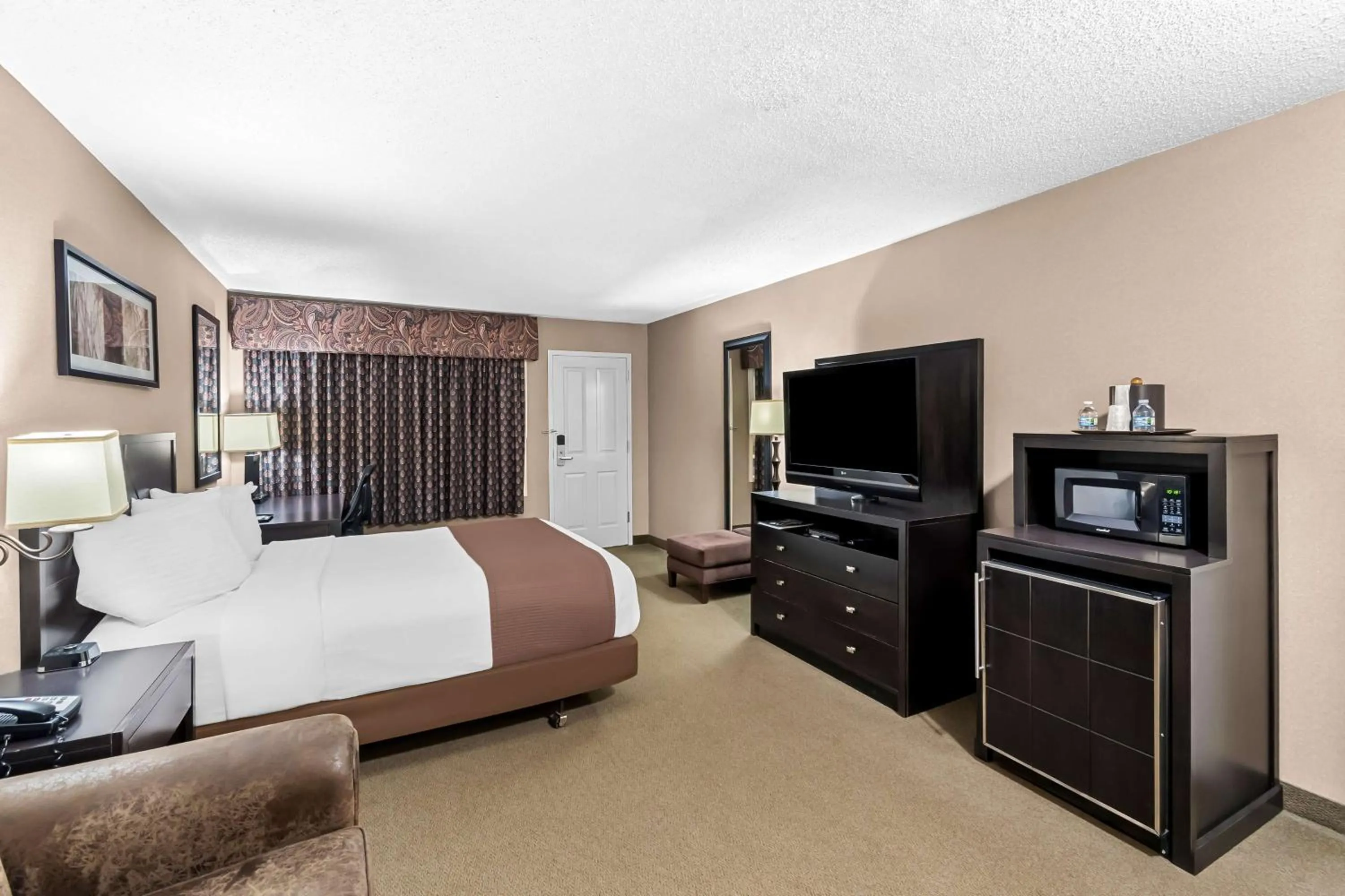 Bedroom, Bed in Heartland Inn & Suites, SureStay Collection by Best Western