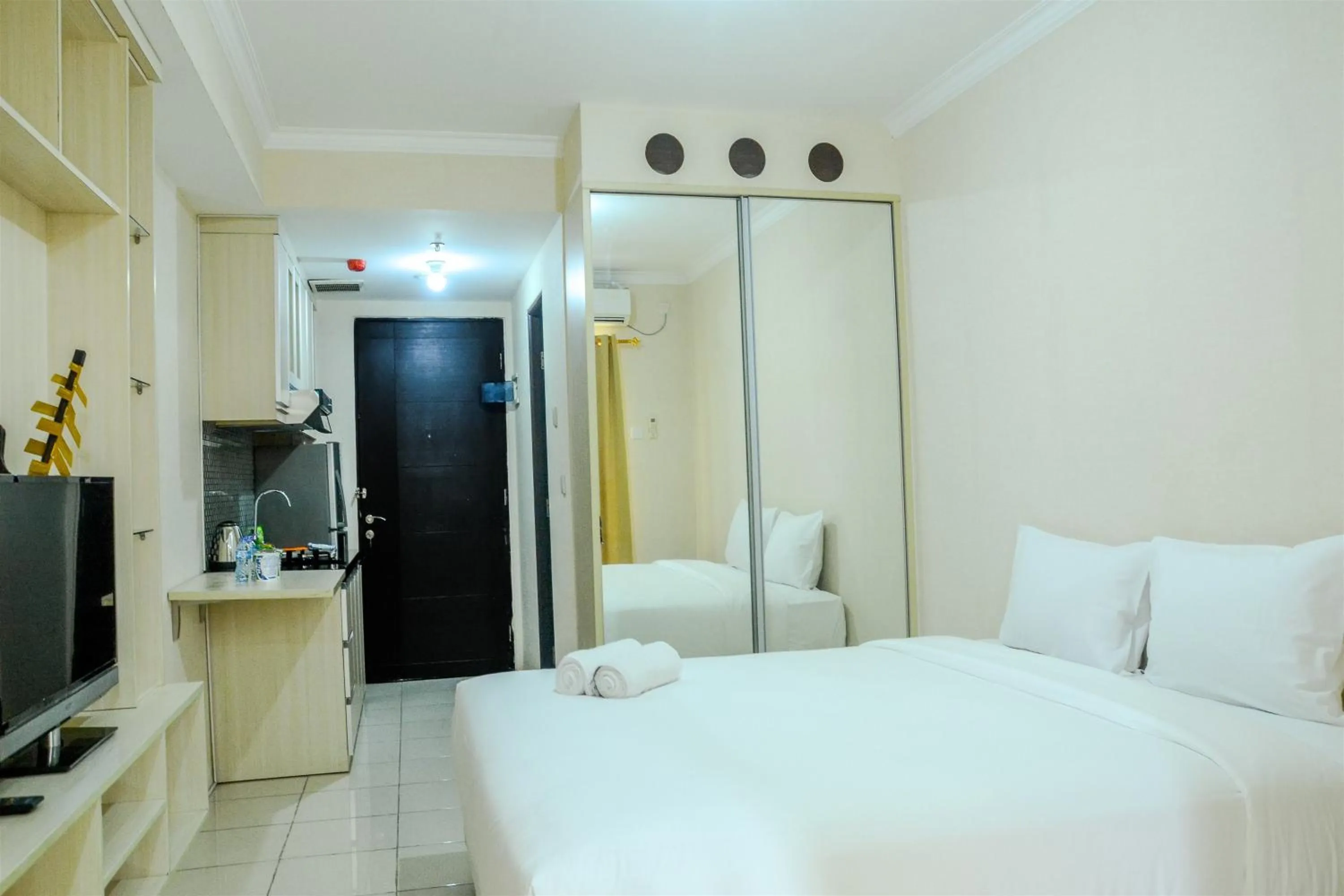 Bed in Minimalist Studio Room at Grand Serpong Apartment By Travelio