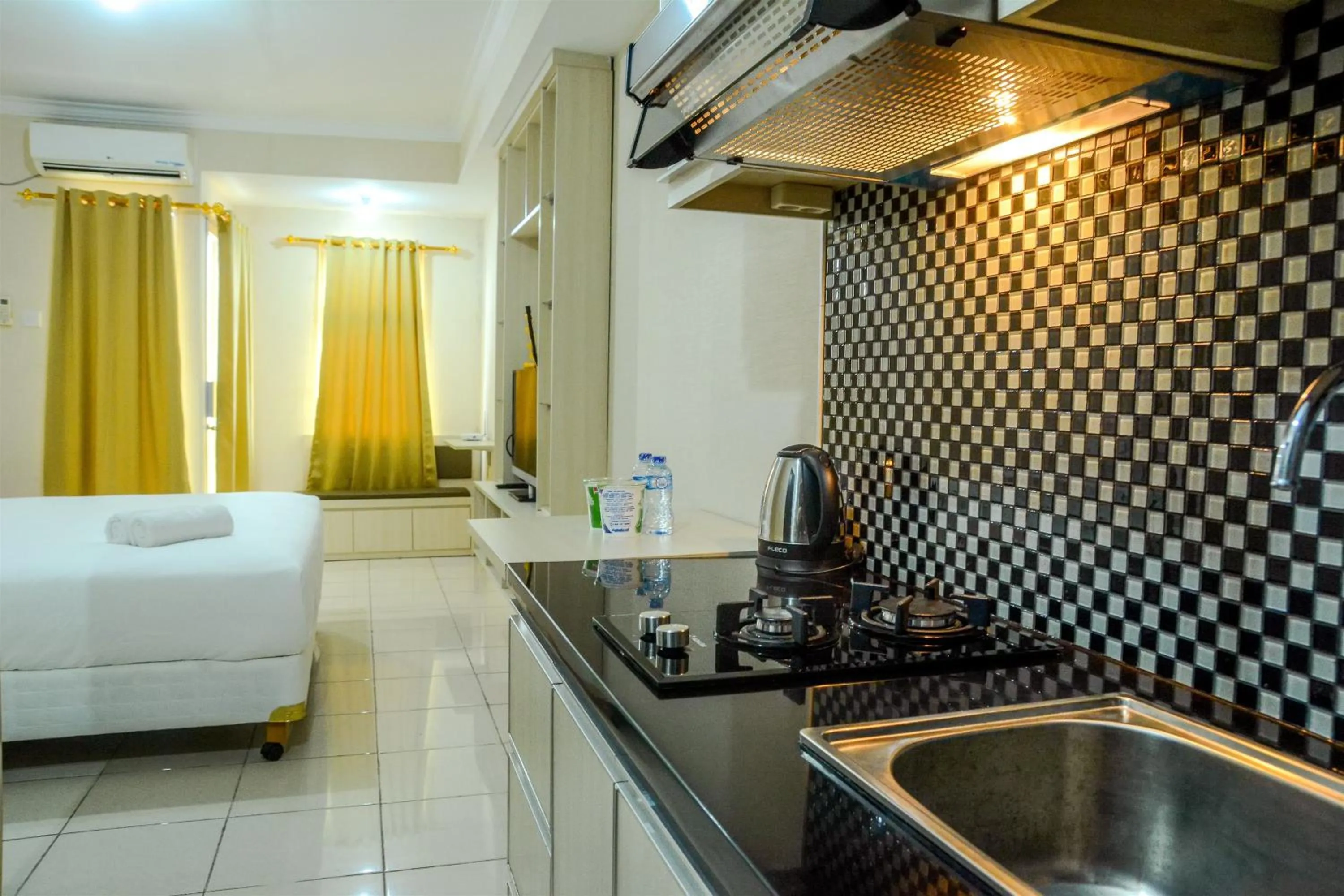 Kitchen or kitchenette in Minimalist Studio Room at Grand Serpong Apartment By Travelio