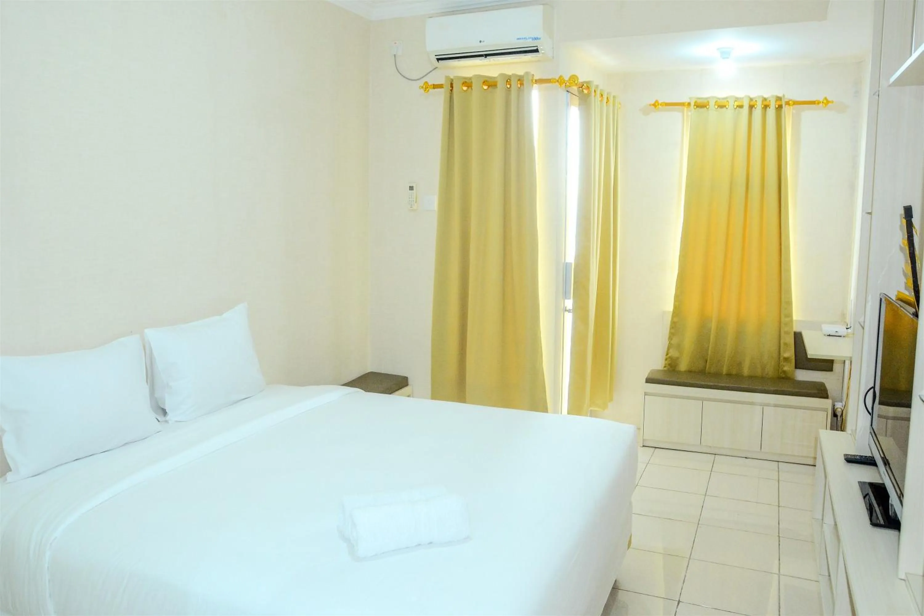 Bed in Minimalist Studio Room at Grand Serpong Apartment By Travelio