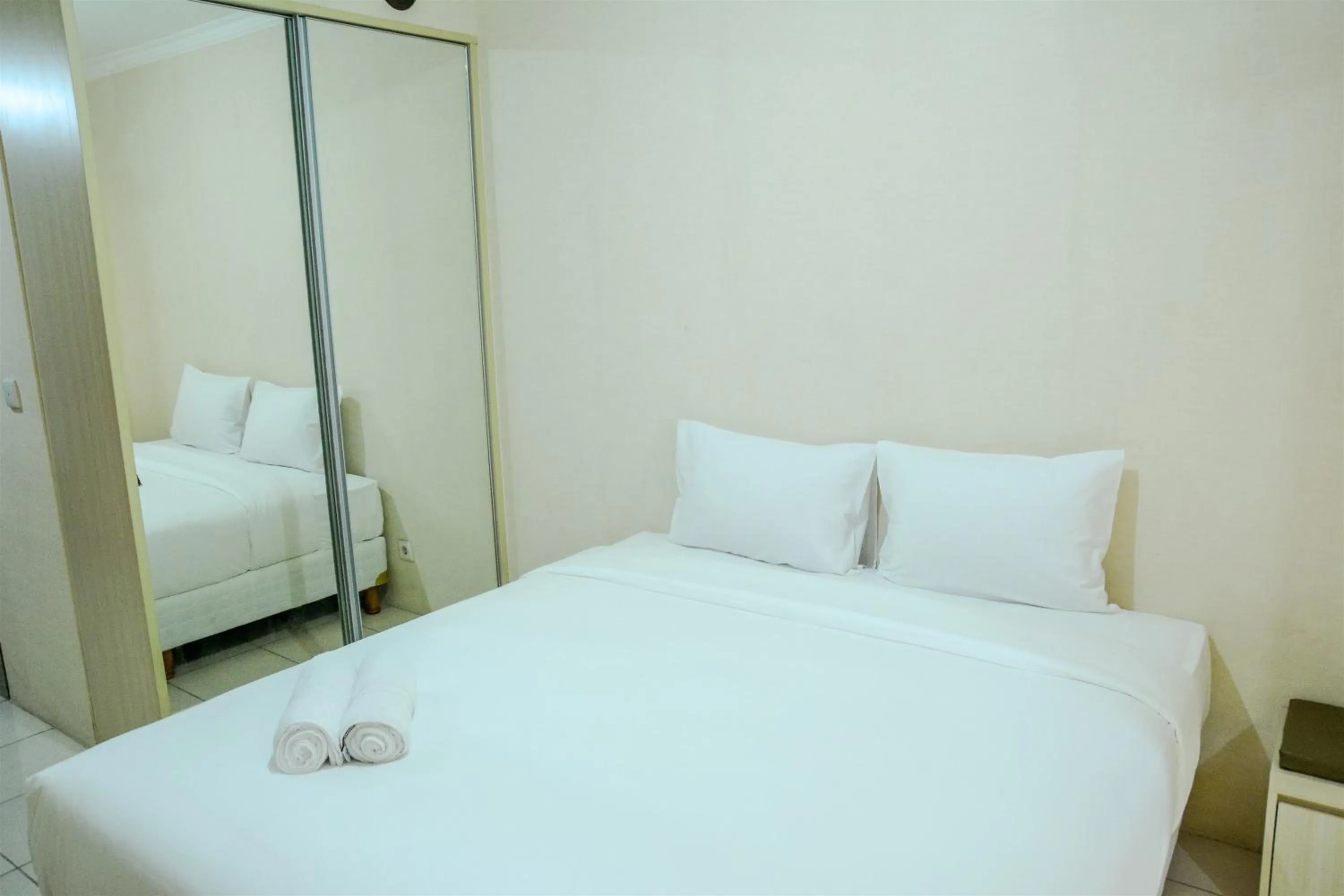 Bed in Minimalist Studio Room at Grand Serpong Apartment By Travelio