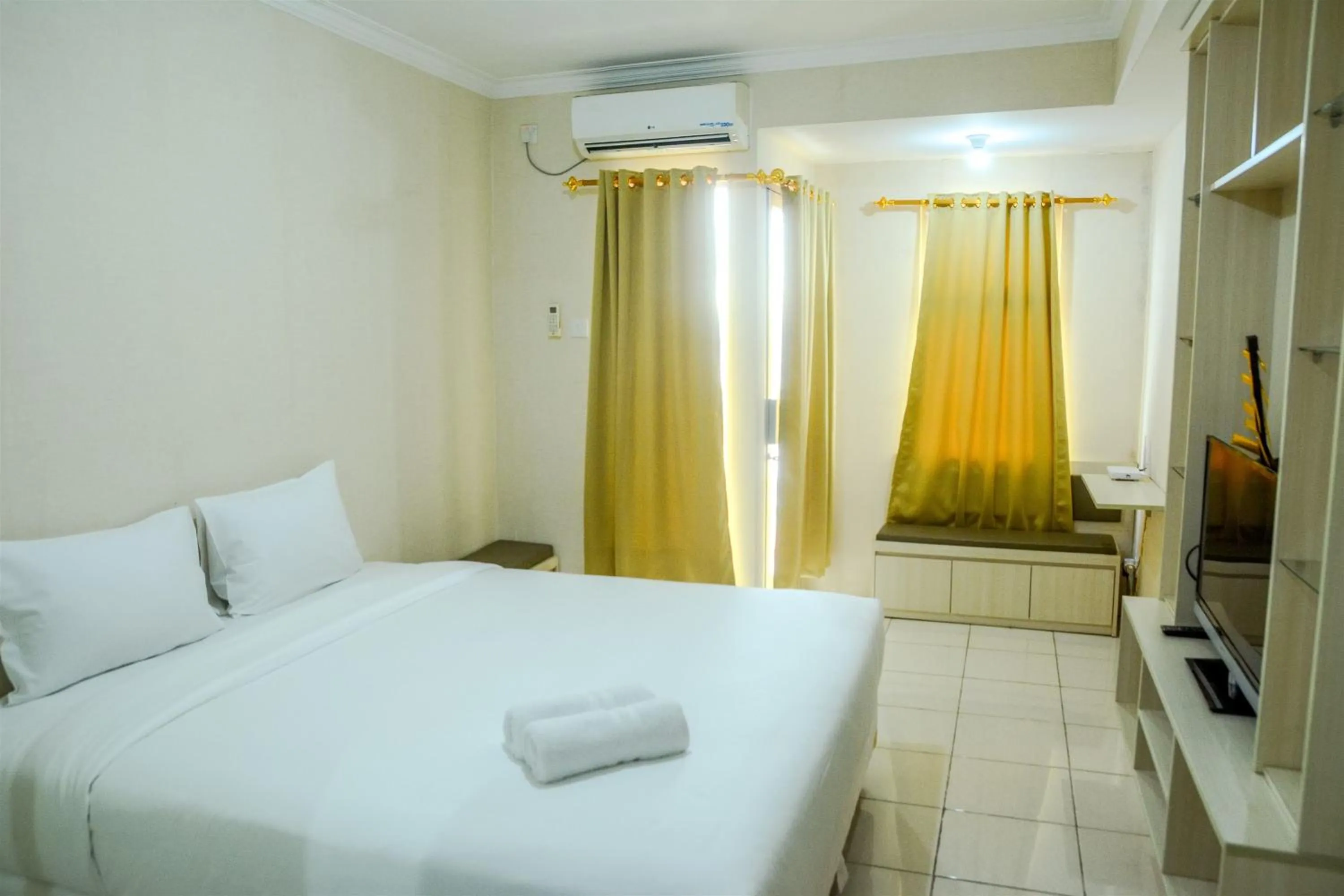 Bed in Minimalist Studio Room at Grand Serpong Apartment By Travelio
