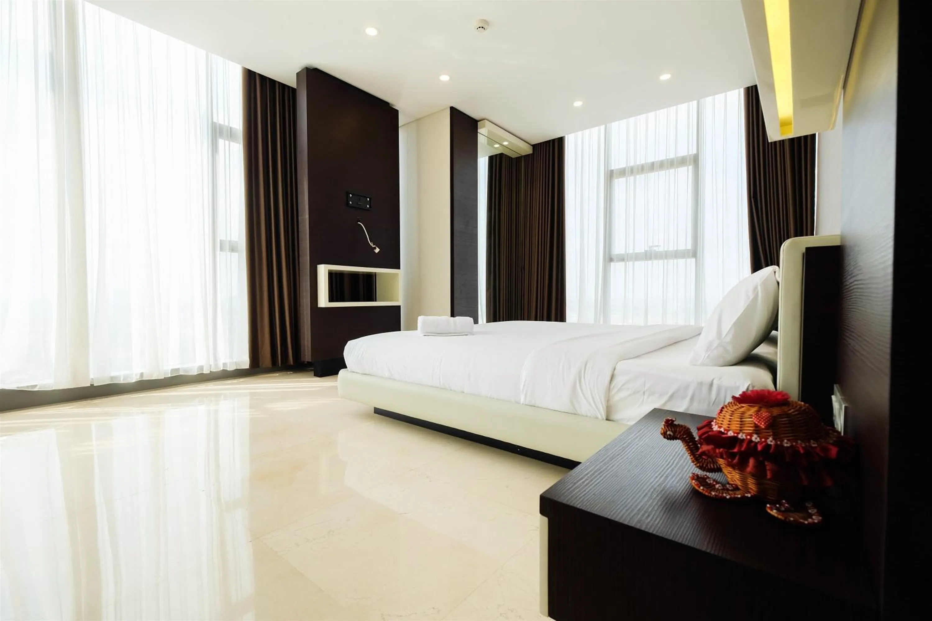 Bed in Modern Elegant Design 2BR L'Avenue Apartment By Travelio