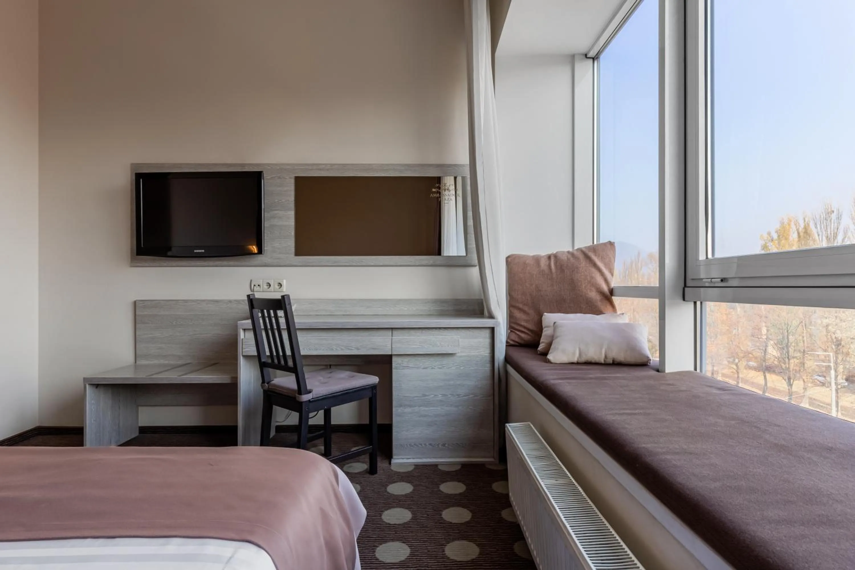 Communal lounge/ TV room, Bed in Ambassador Plaza