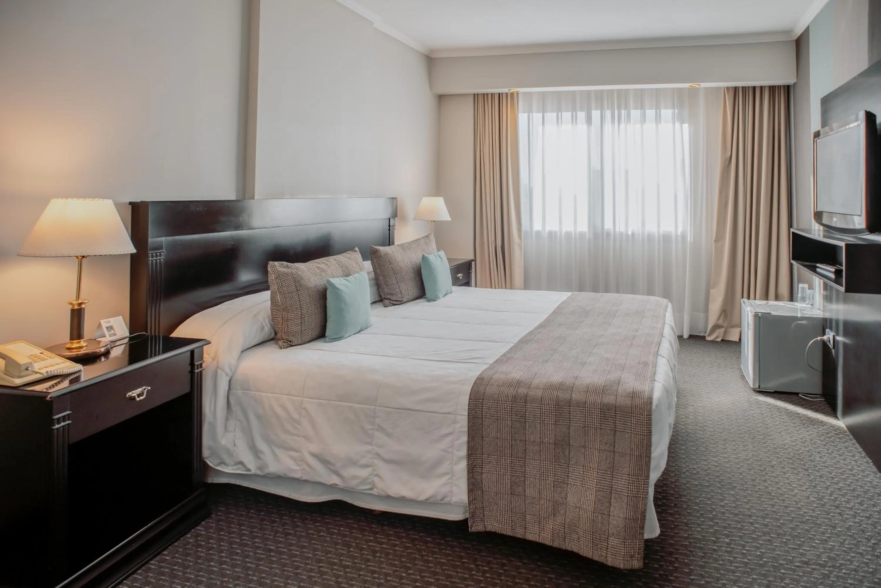 Bed in Plaza Real Suites Hotel