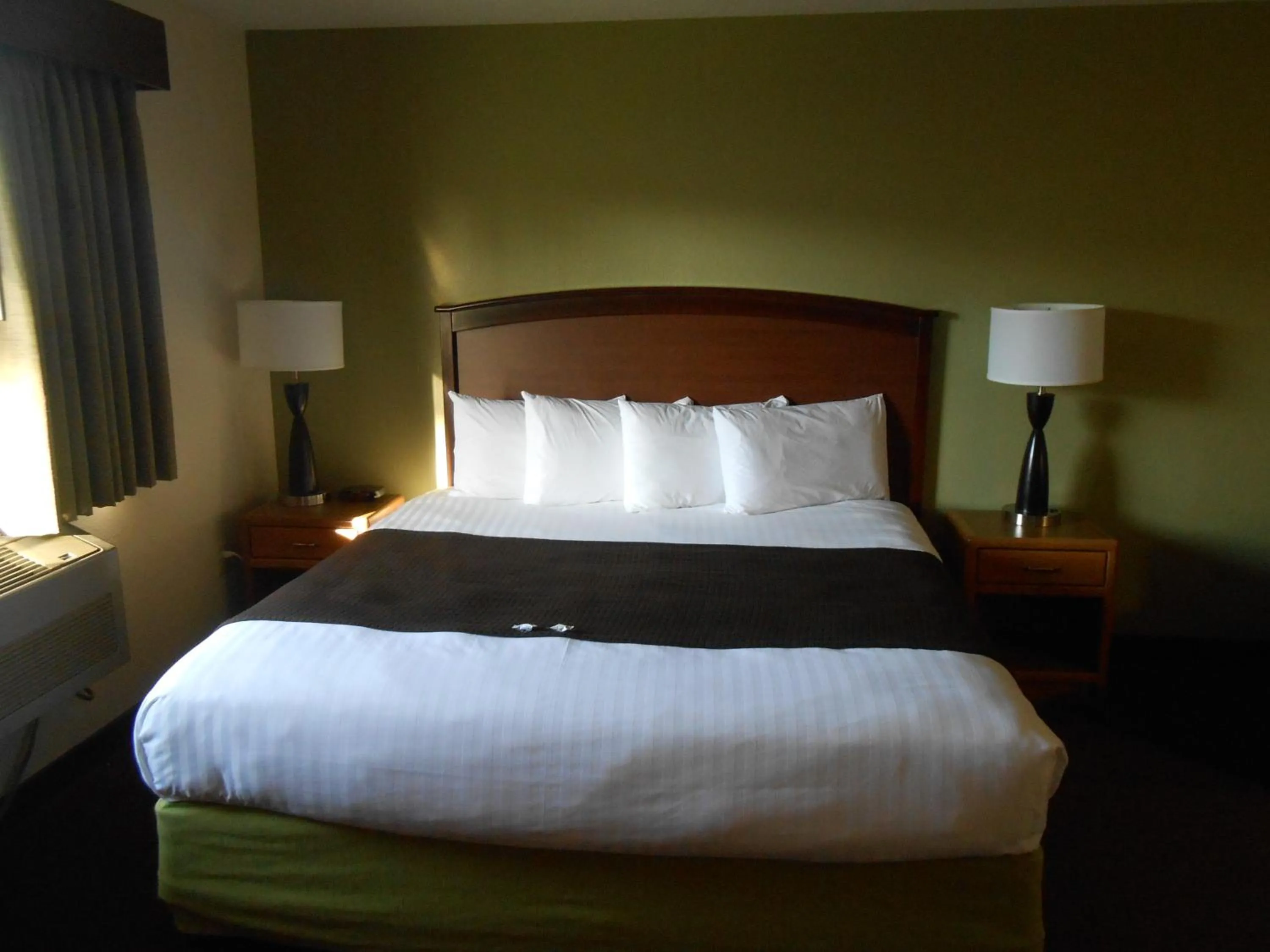 Bed in AmericInn by Wyndham Grand Rapids