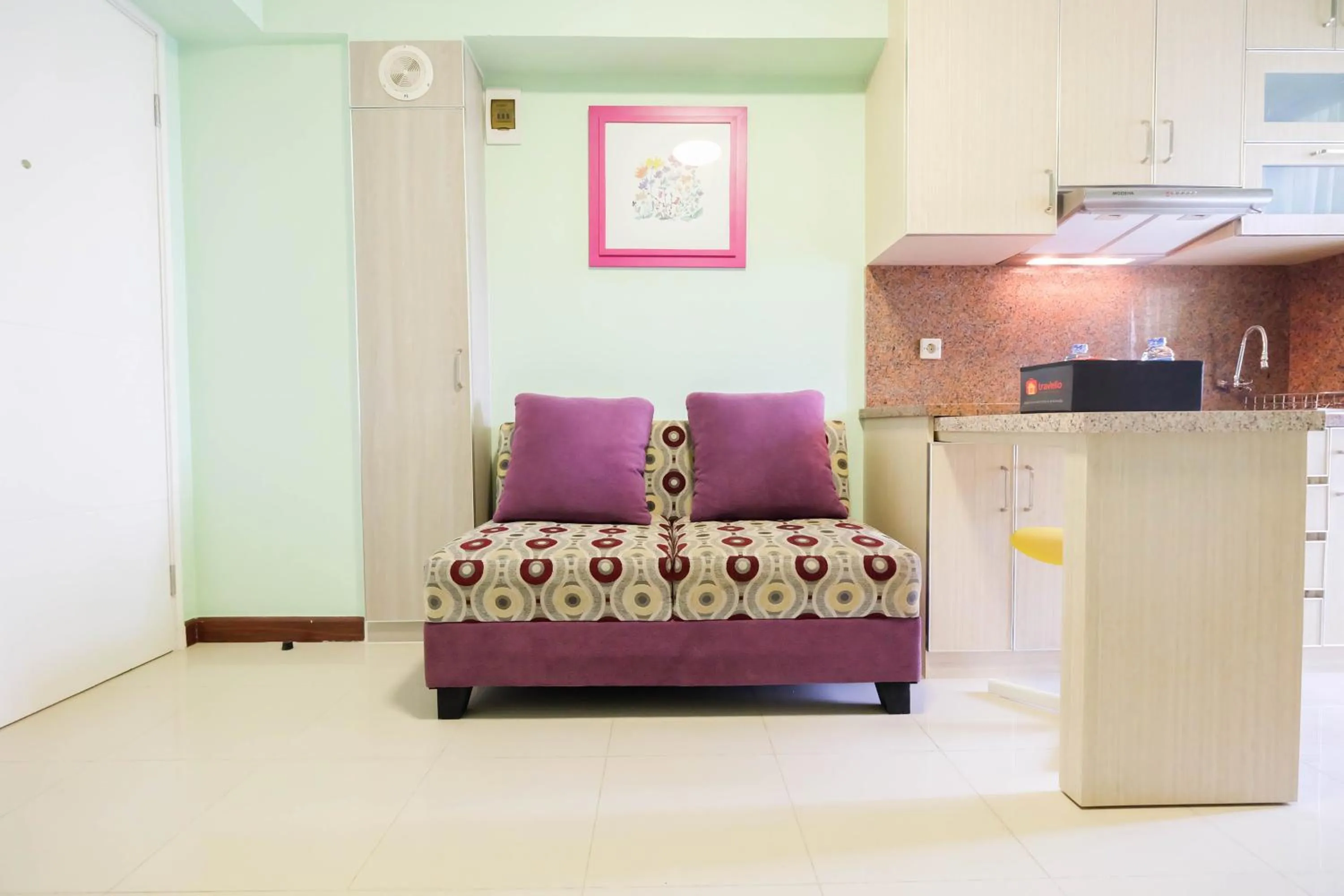 Living room in Cozy 2BR Bassura City Apartment By Travelio