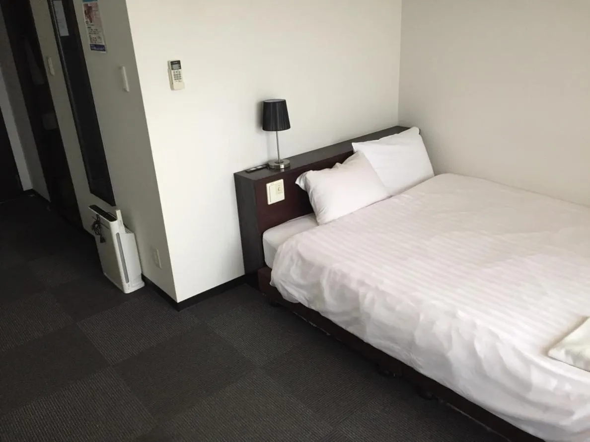 Bed in Omura Station Hotel