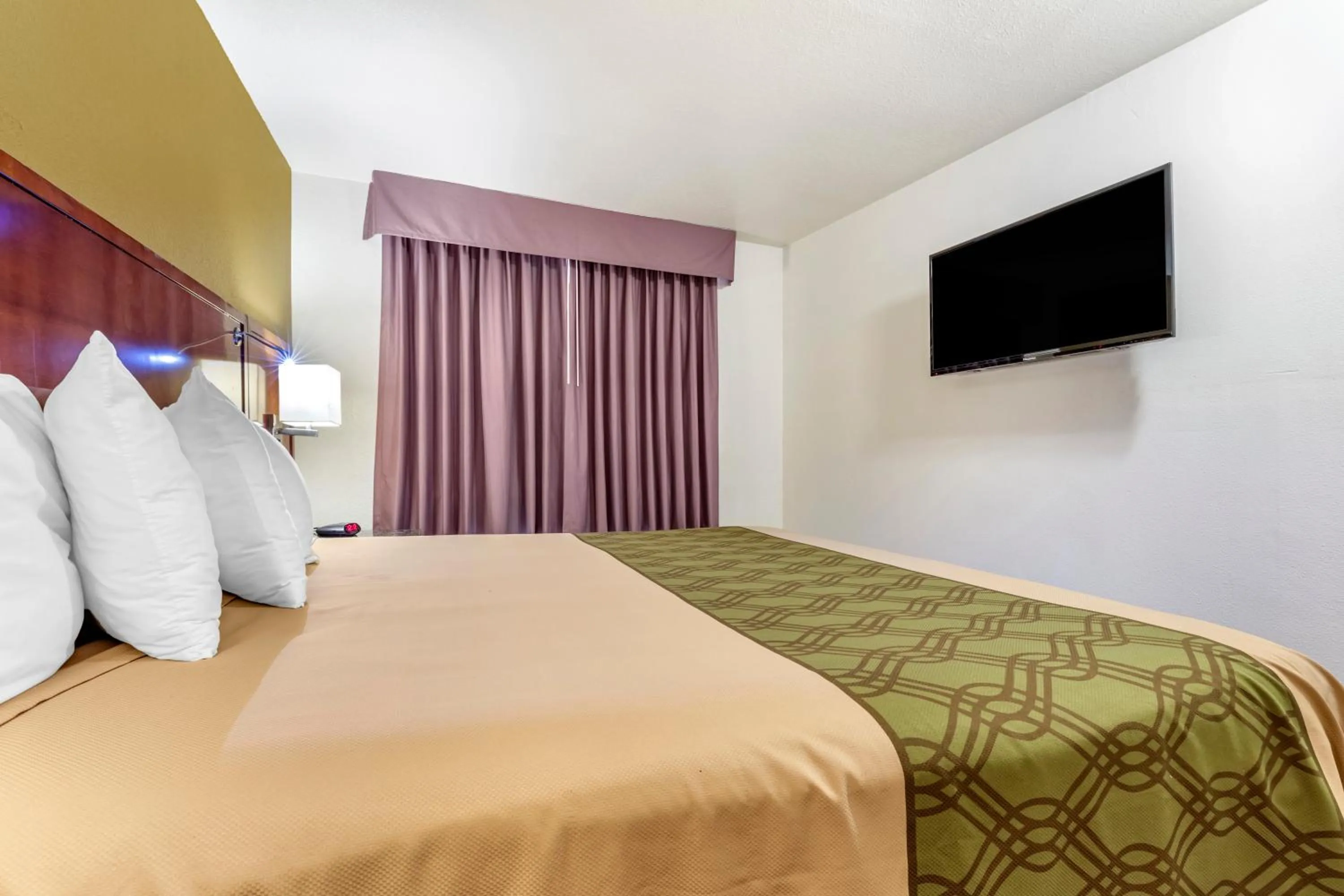 Bed in Rose City Inn & Suites