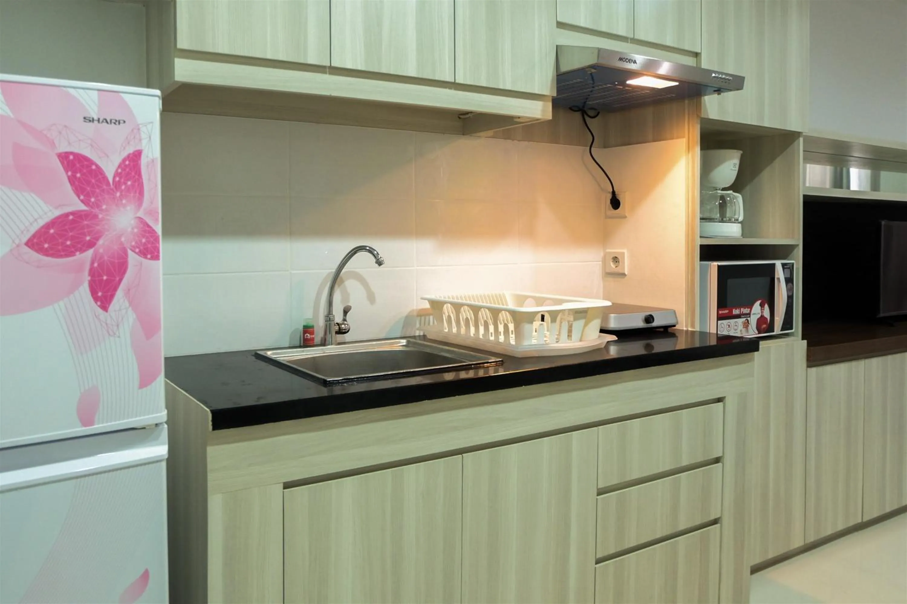 Kitchen or kitchenette in Studio Room Azalea Suites Apartment By Travelio