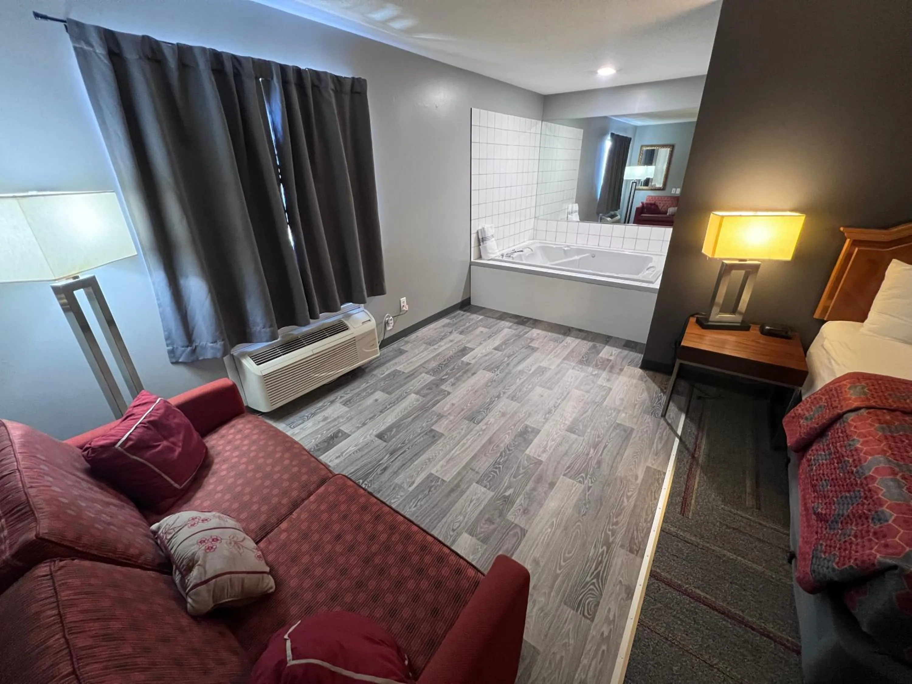Seating area, Bed in American Inn and Suites Ionia