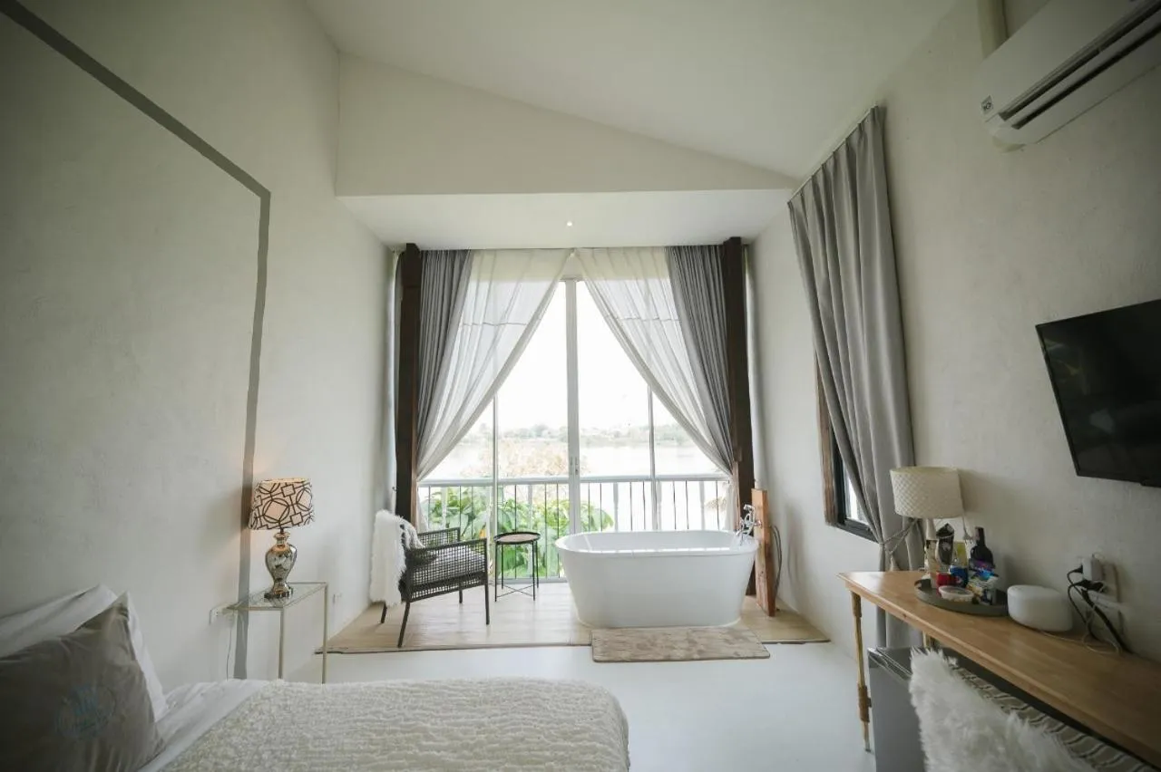 Bed in White Wall Riverfront Hotel