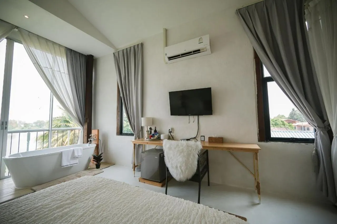 Bed in White Wall Riverfront Hotel