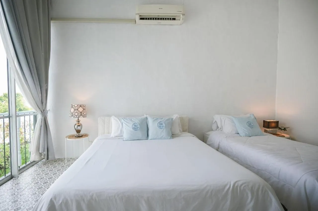 Bed in White Wall Riverfront Hotel