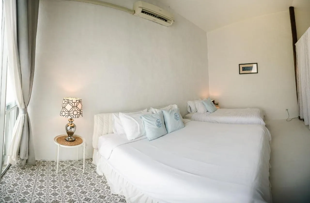 Bed in White Wall Riverfront Hotel