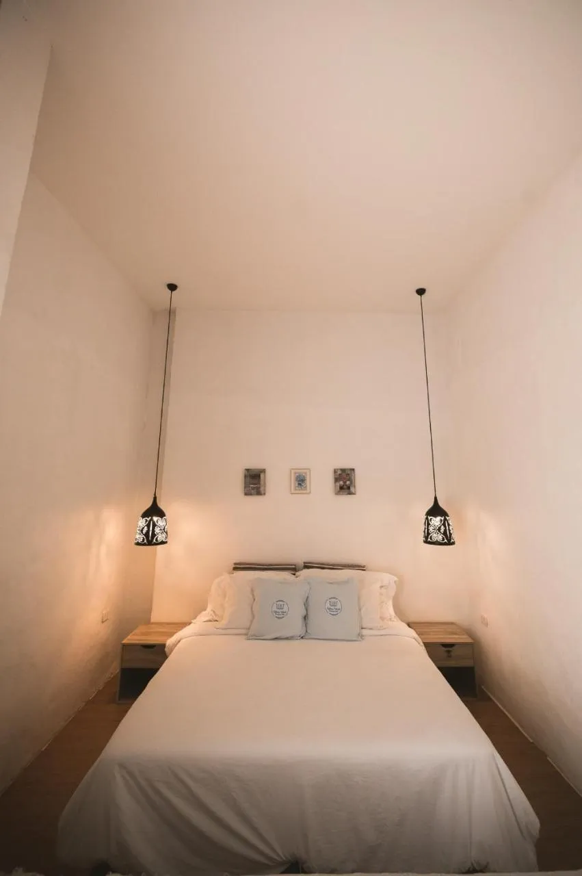 Bed in White Wall Riverfront Hotel