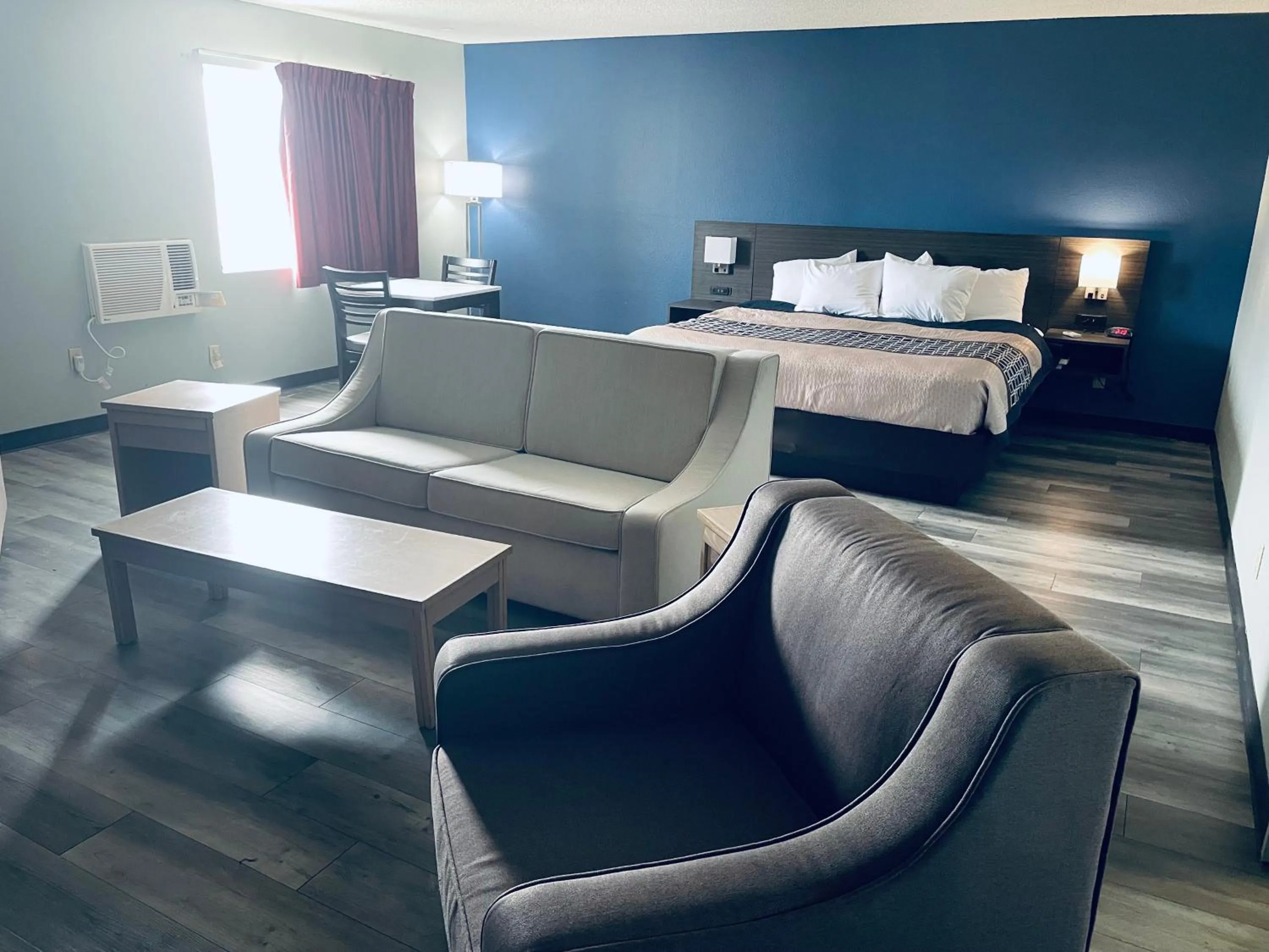 Seating area, Bed in Americas Choice Inn & Suites