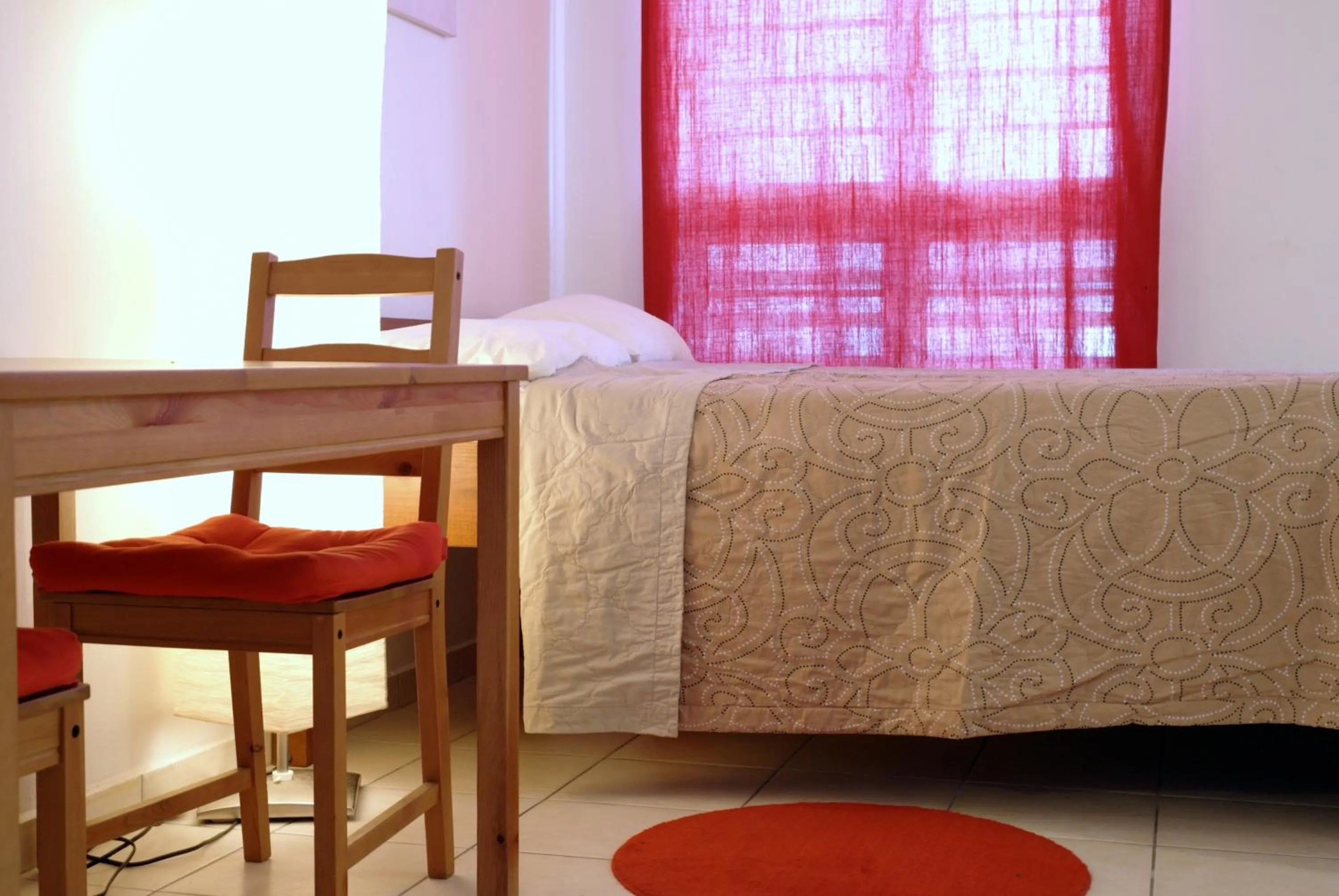 Bed in Orange Rembrandt Studio Apartments