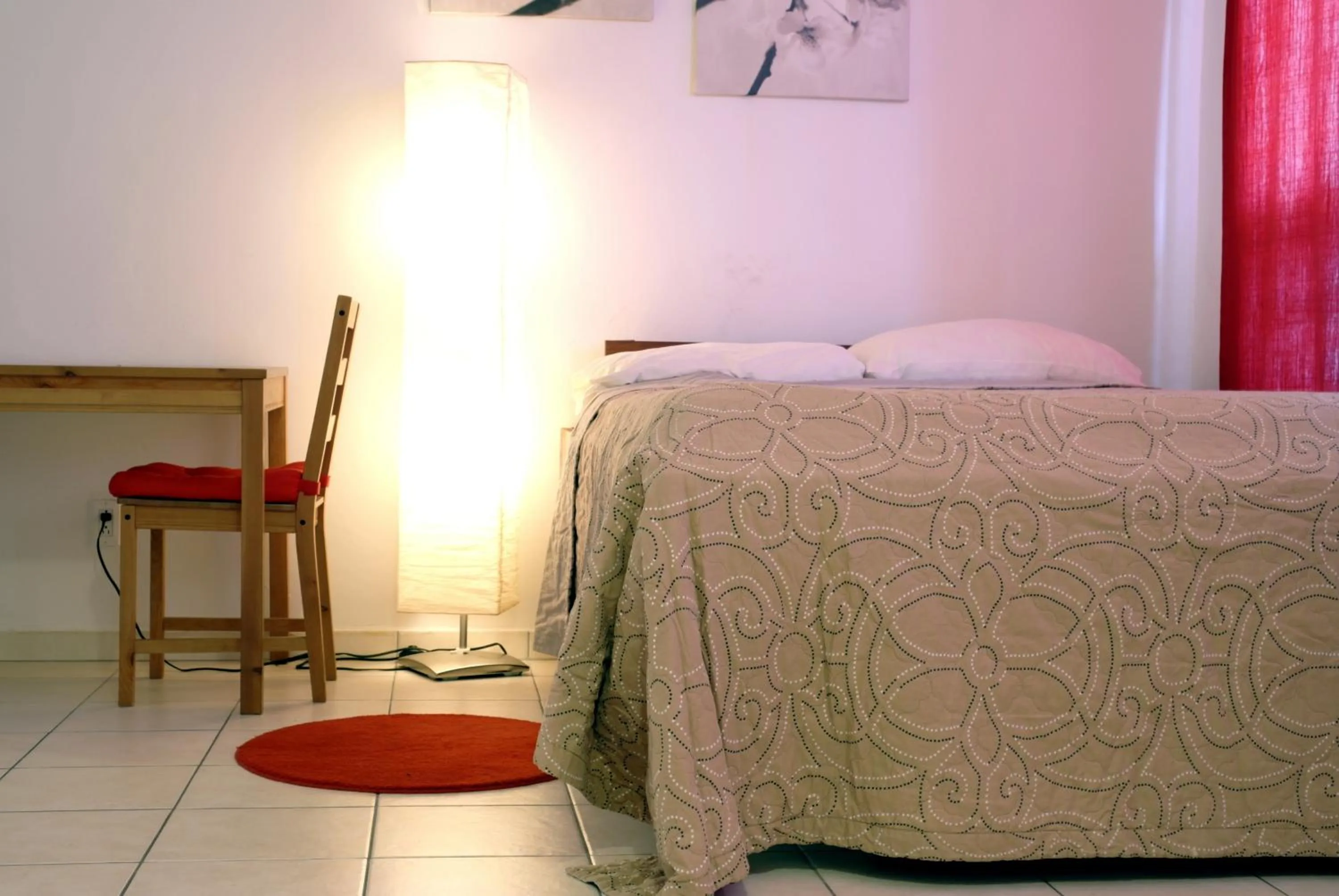 Bed in Orange Rembrandt Studio Apartments