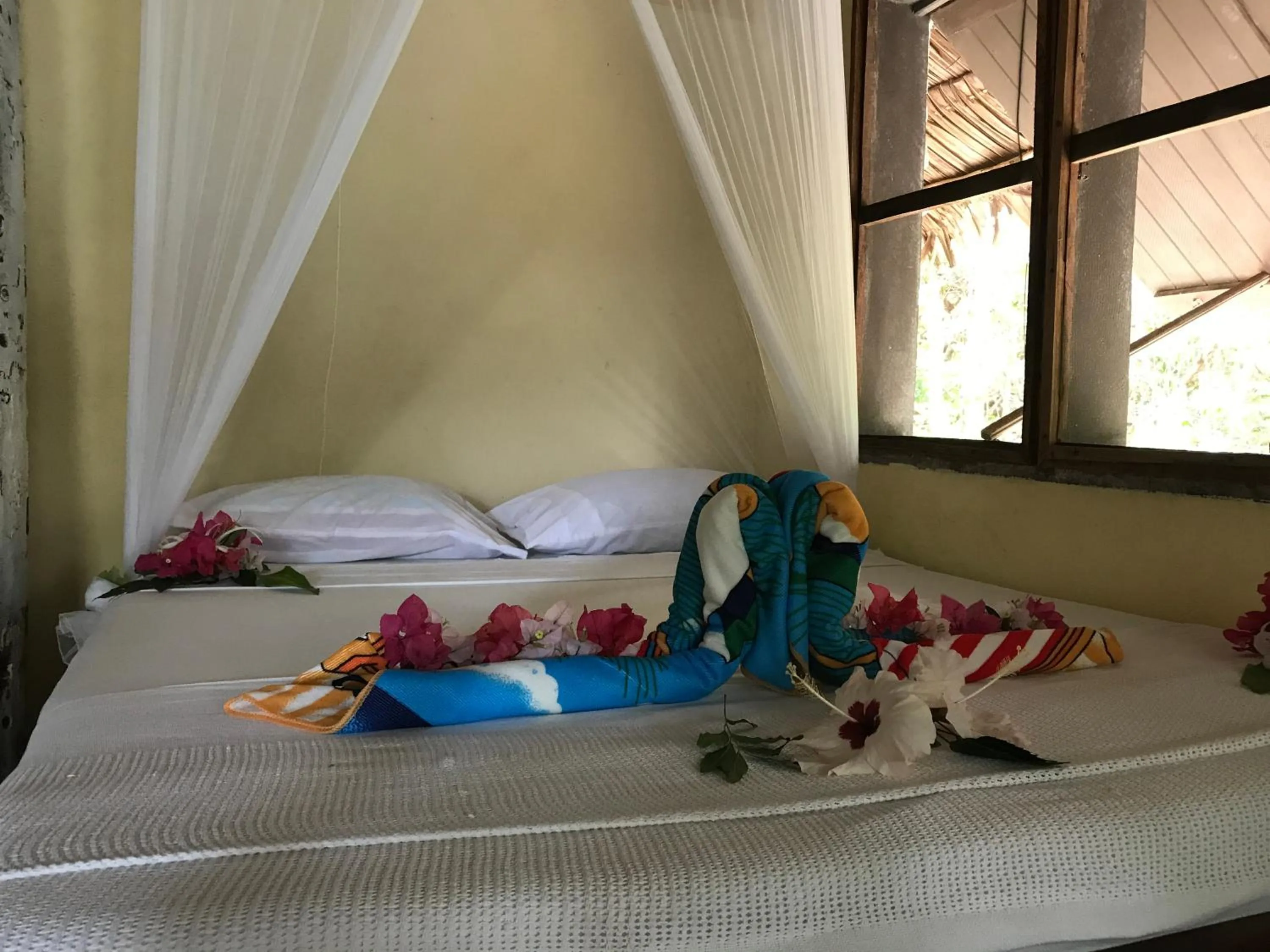 Bed in Tranquility Island Eco Dive Resort