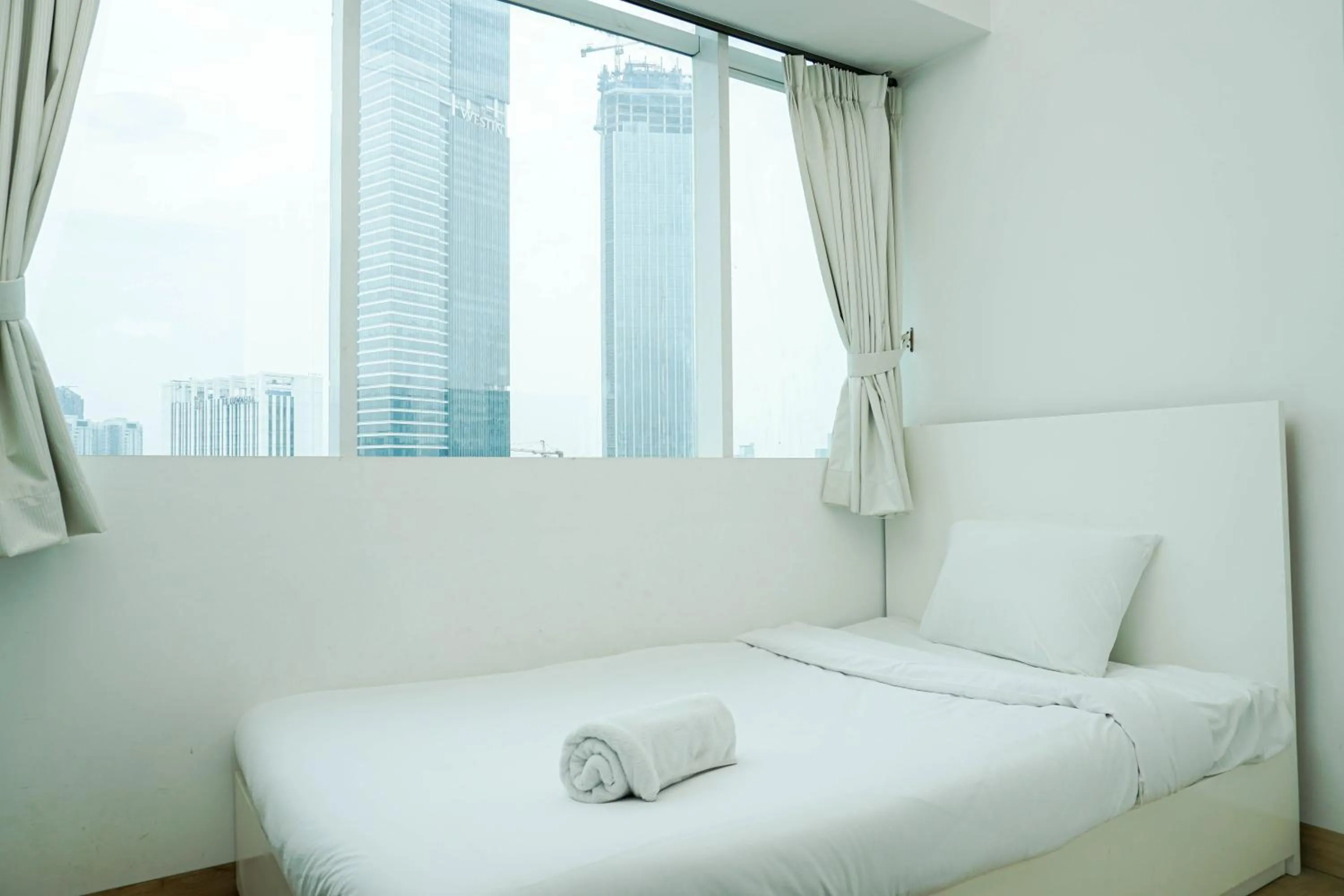 Bed in Spacious 3BR Ambassade Kuningan Apartment By Travelio