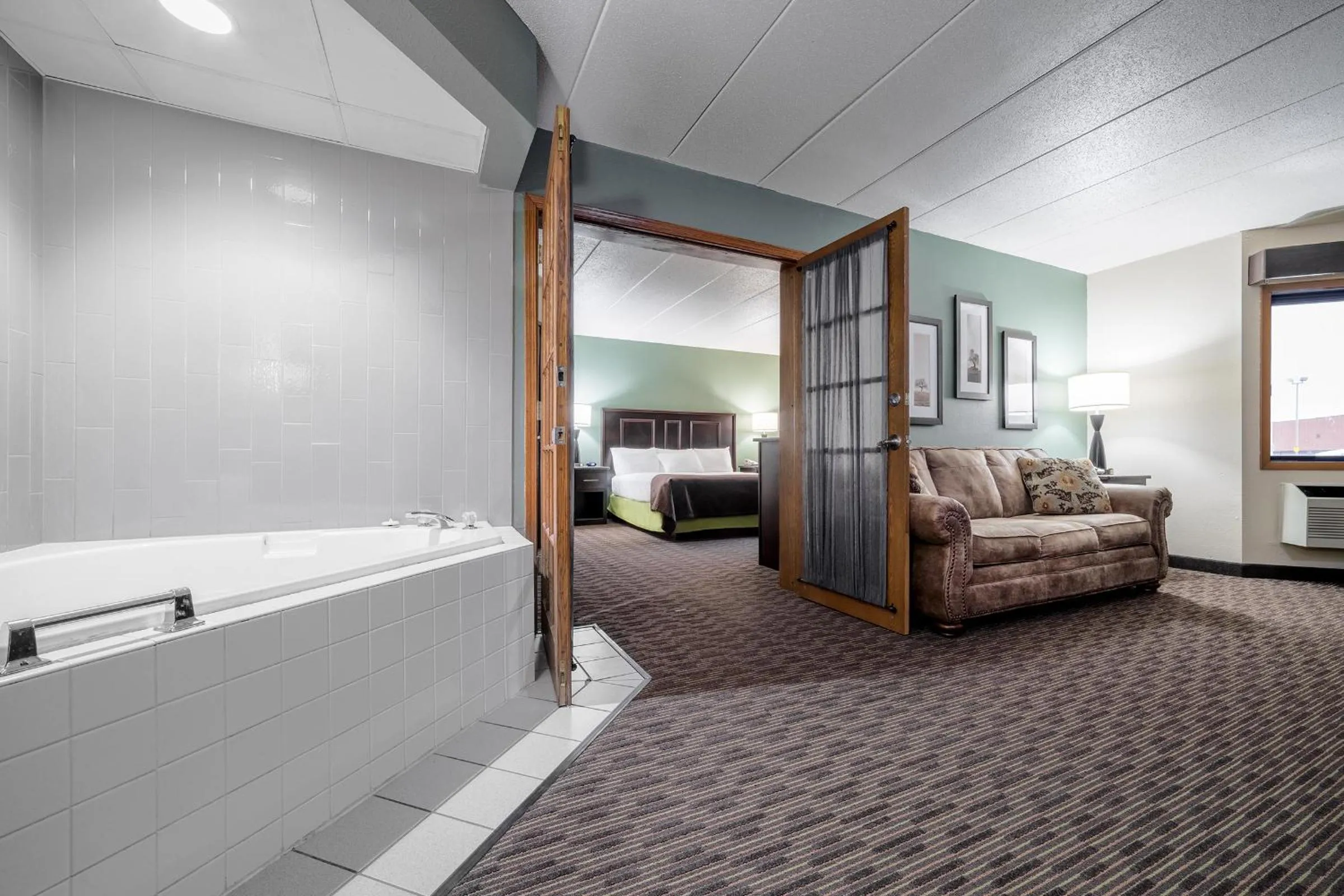 Living room, Bed in AmericInn by Wyndham West Salem