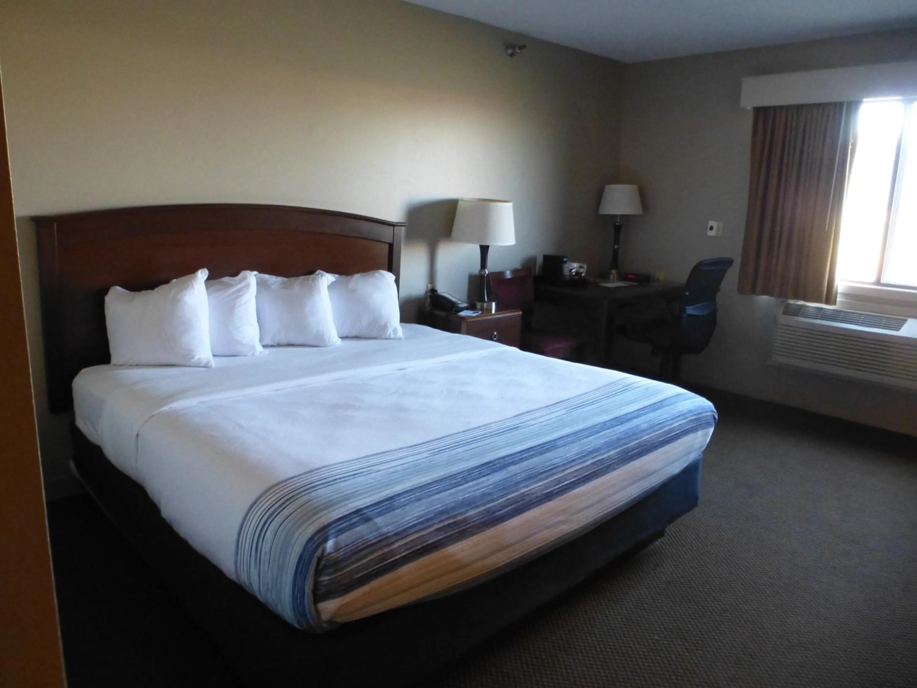 Bed in AmericInn by Wyndham Mitchell