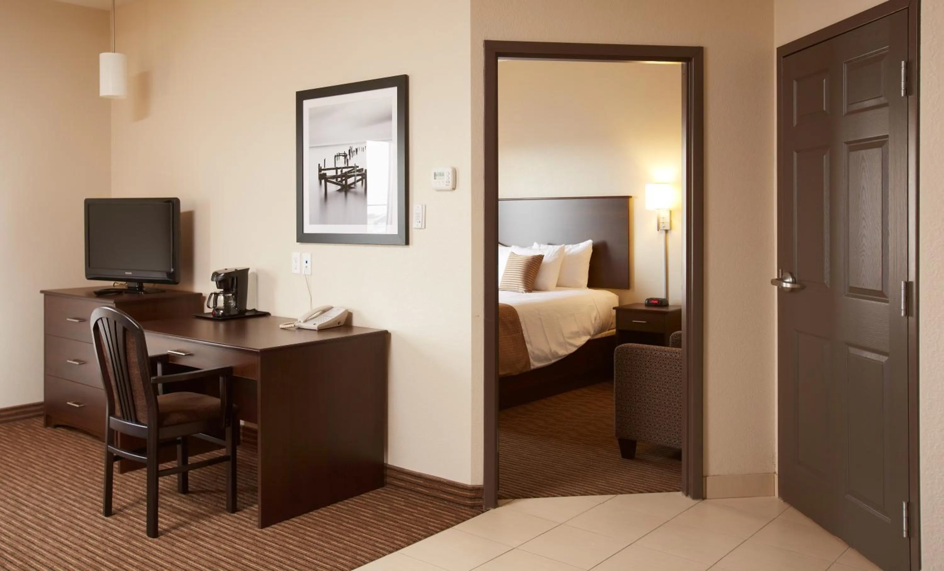 Living room, Bed in Travelodge Suites by Wyndham Estevan