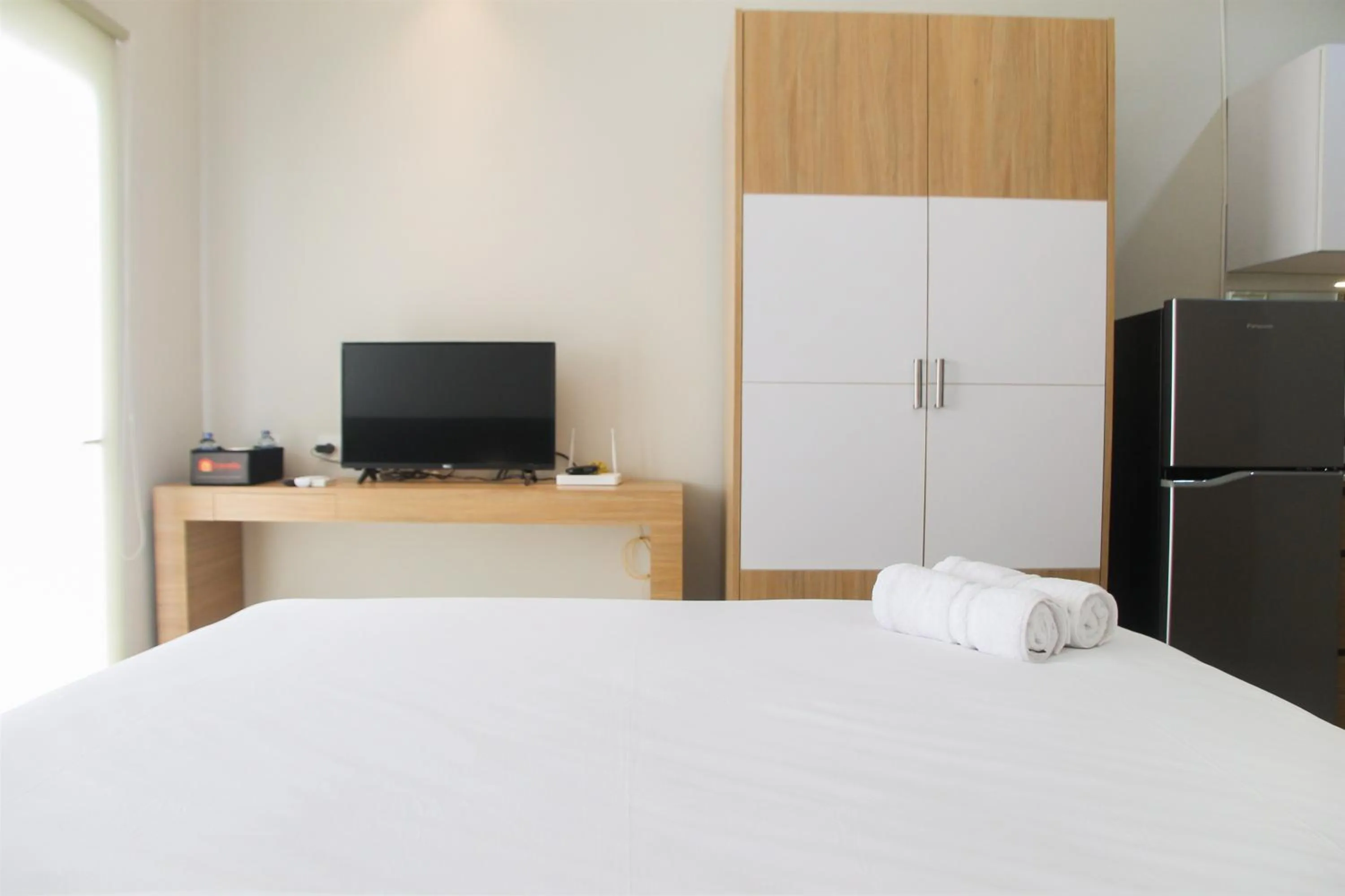 Bed in Comfy Studio Room The Oasis Cikarang Apartment By Travelio