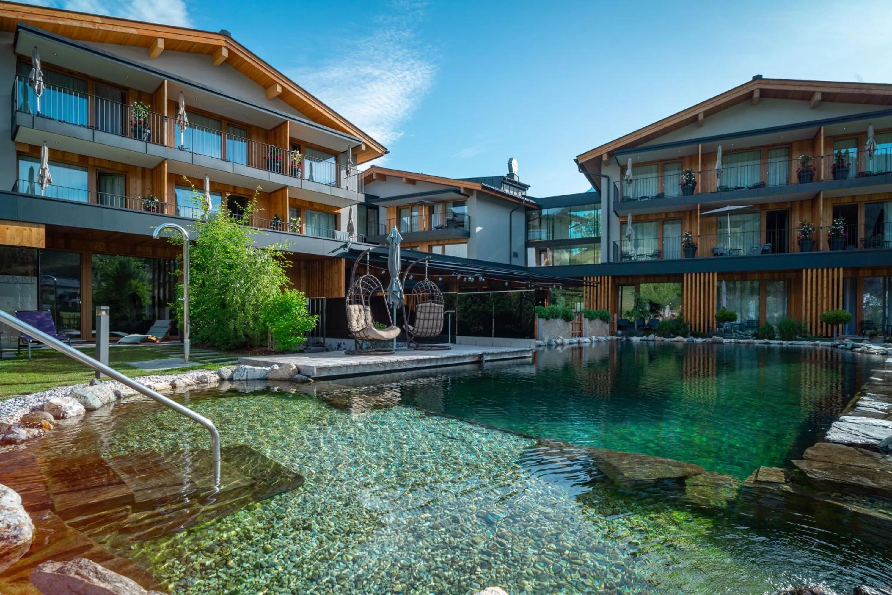 Pool view in Wellness und Brunch Hotel MorgenZeit beheizter Naturpool mit Sandstrand Genuss Frühstück bis 13 Uhr Hochkönig Sommercard