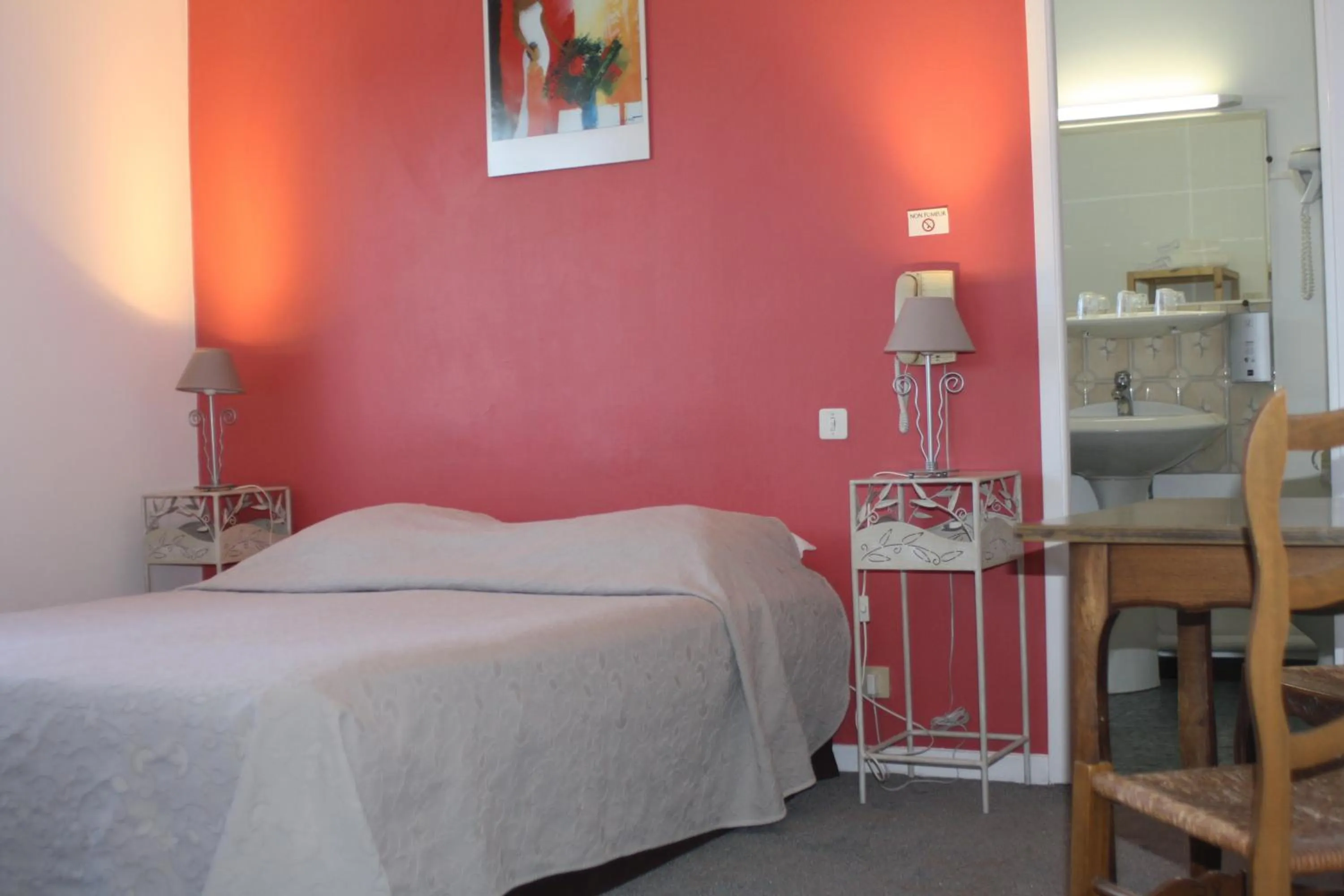 Bed in Logis Hotel du Midi