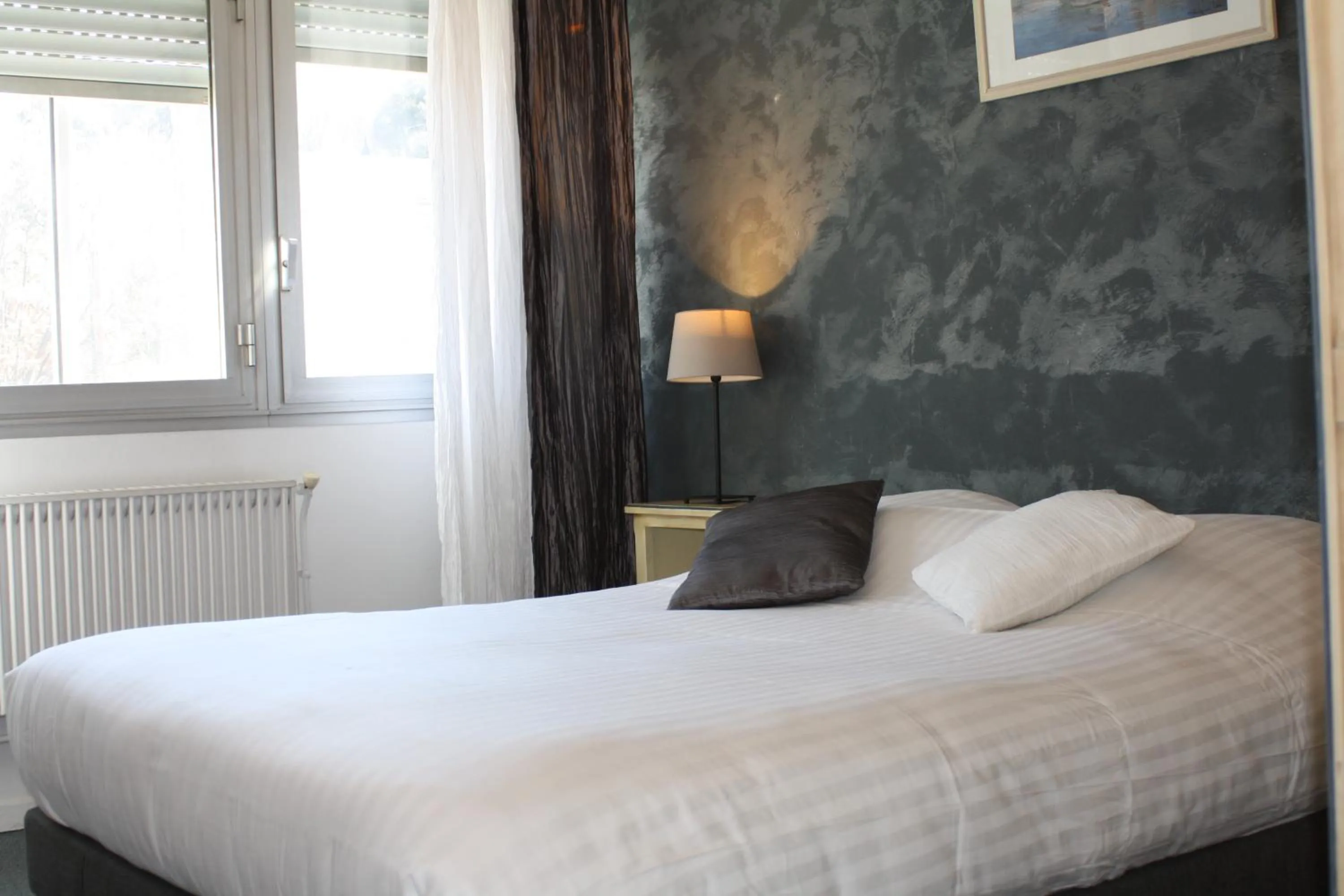 Bed in Logis Hotel du Midi