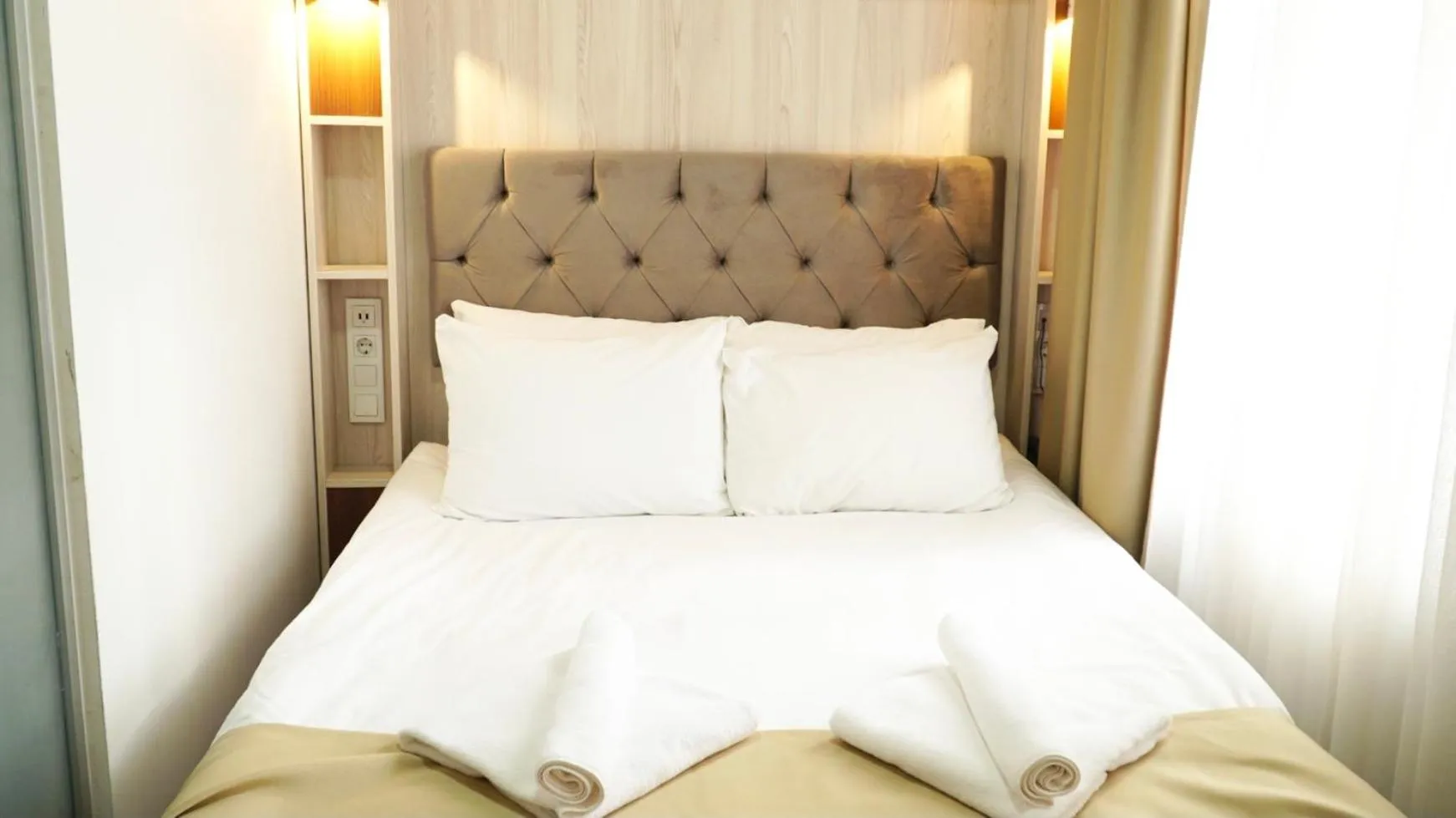 Bed in QONAQ HOTEL & SUITES