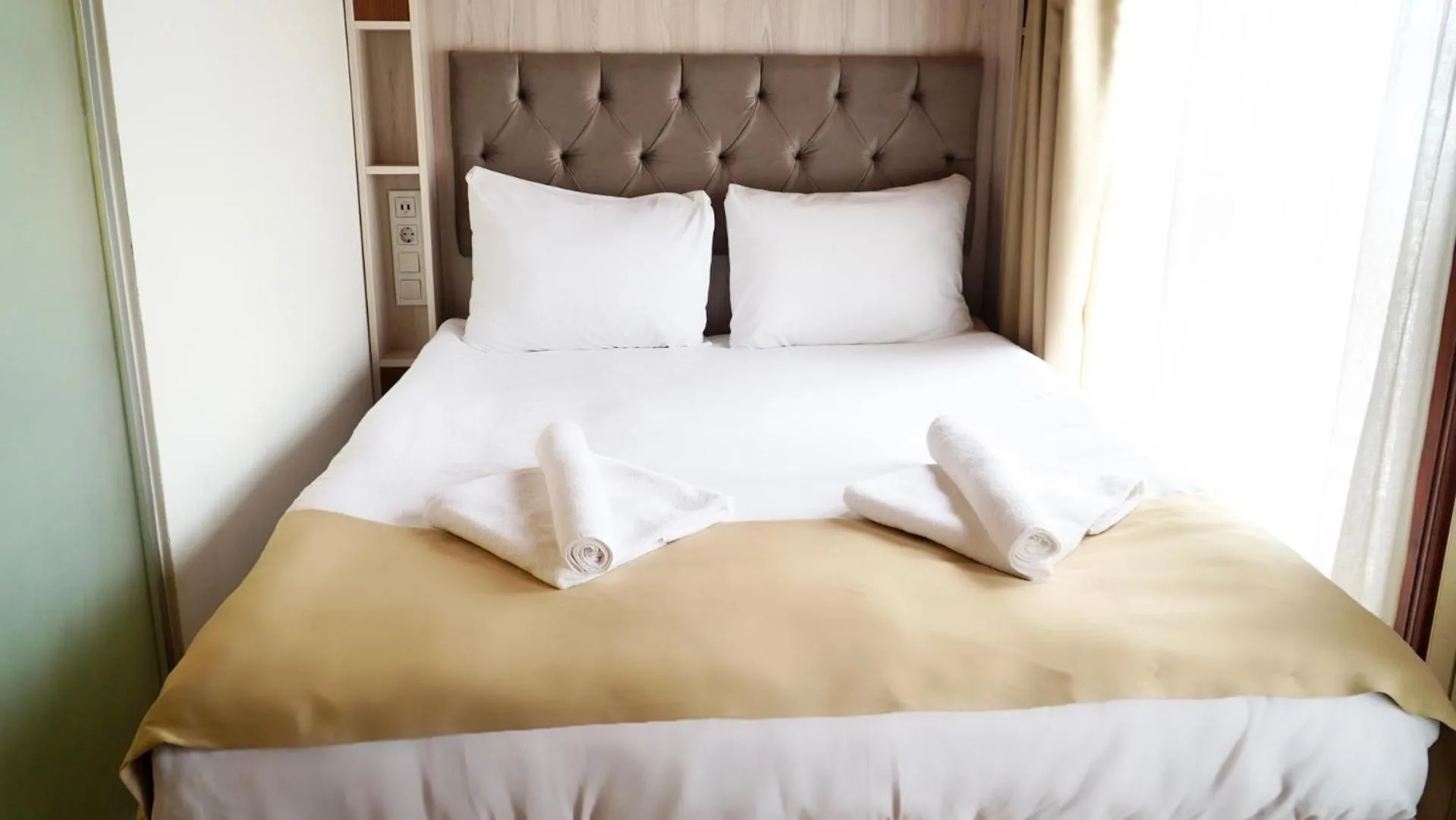 Bed in QONAQ HOTEL & SUITES