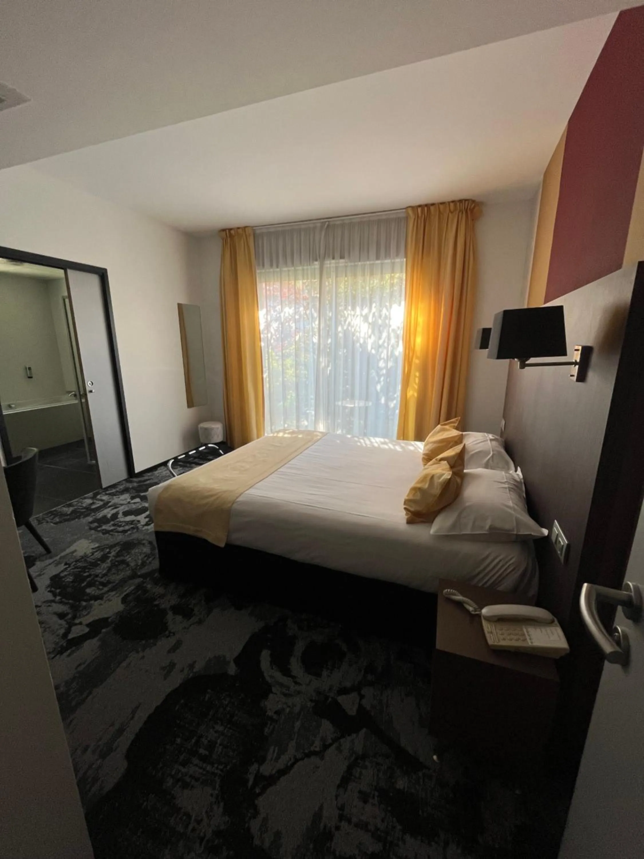 Bed in Logis Hôtel Victor Hugo & Spa