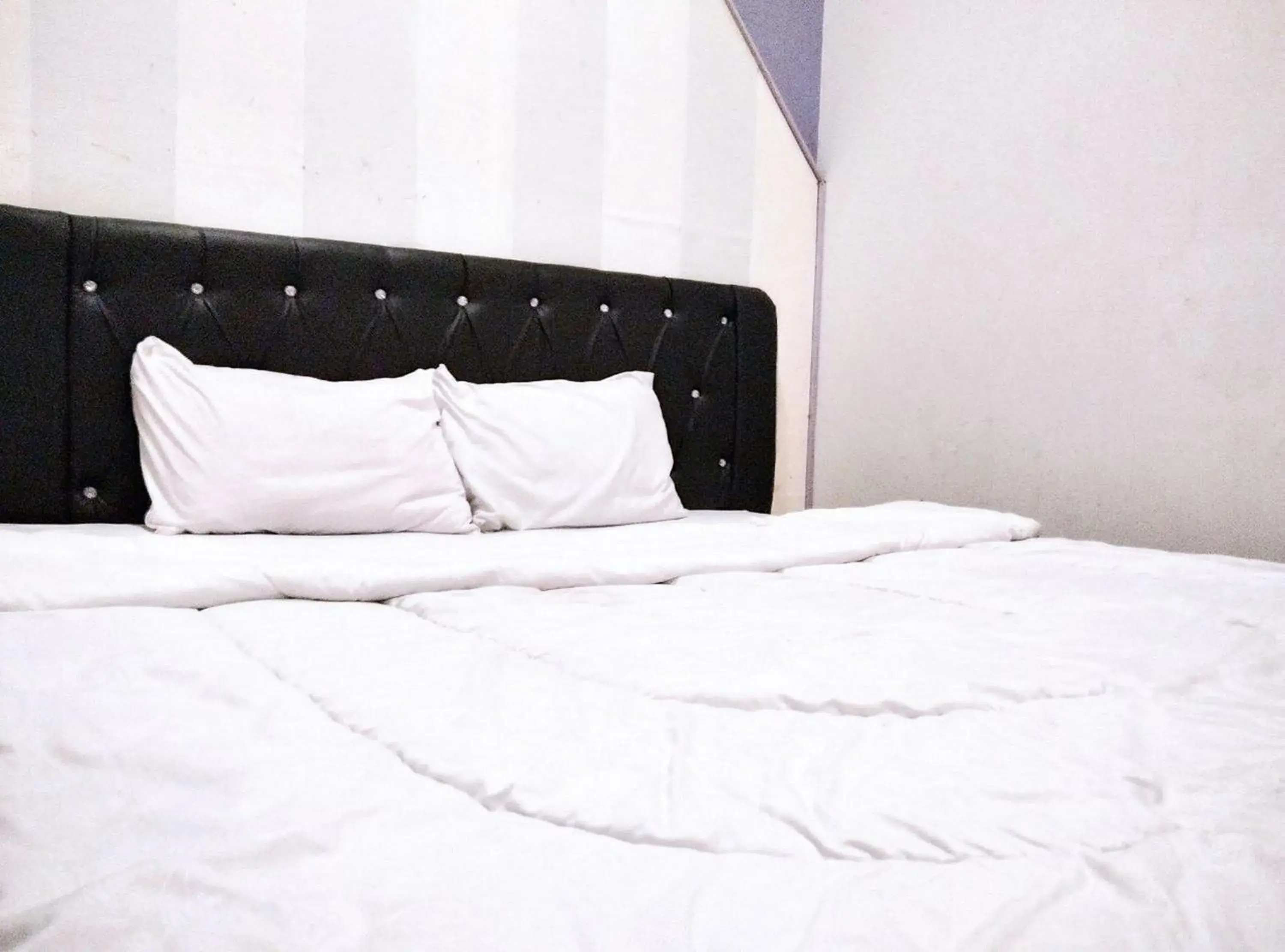 Bed in Gangnam Style Residence Mitra RedDoorz near MERR Surabaya Bed in Gangnam Style Residence Mitra RedDoorz near MERR Surabaya