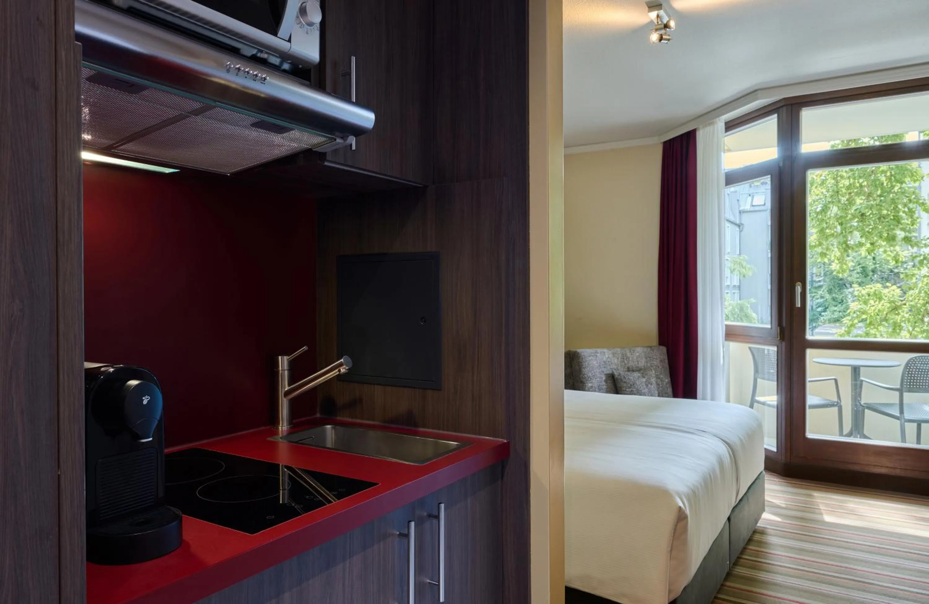 Kitchen or kitchenette, Bed in Leonardo Hotel & Residenz München