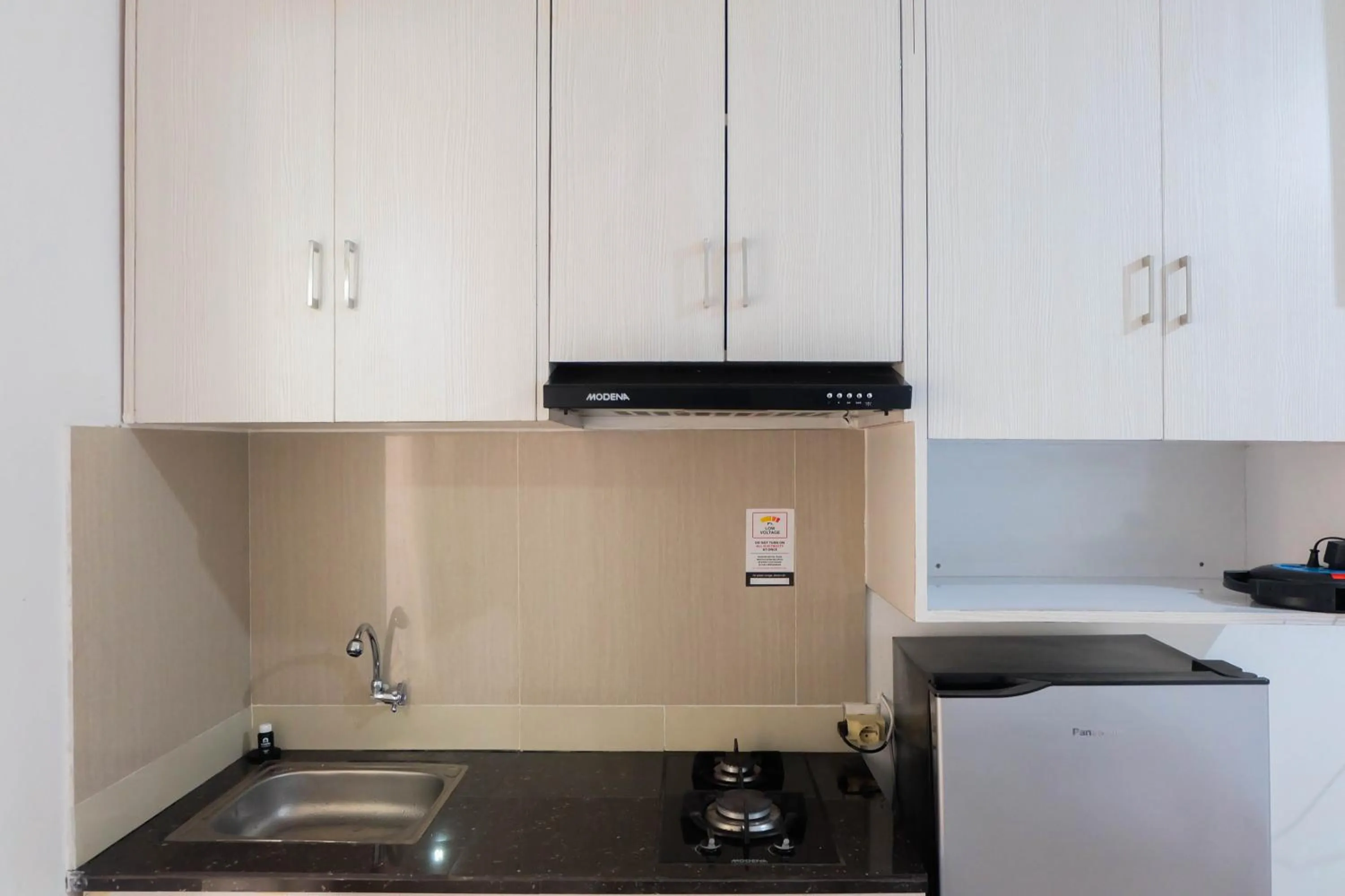 Kitchen or kitchenette in Tidy Studio Apartment at Bassura City near Shopping Mall By Travelio