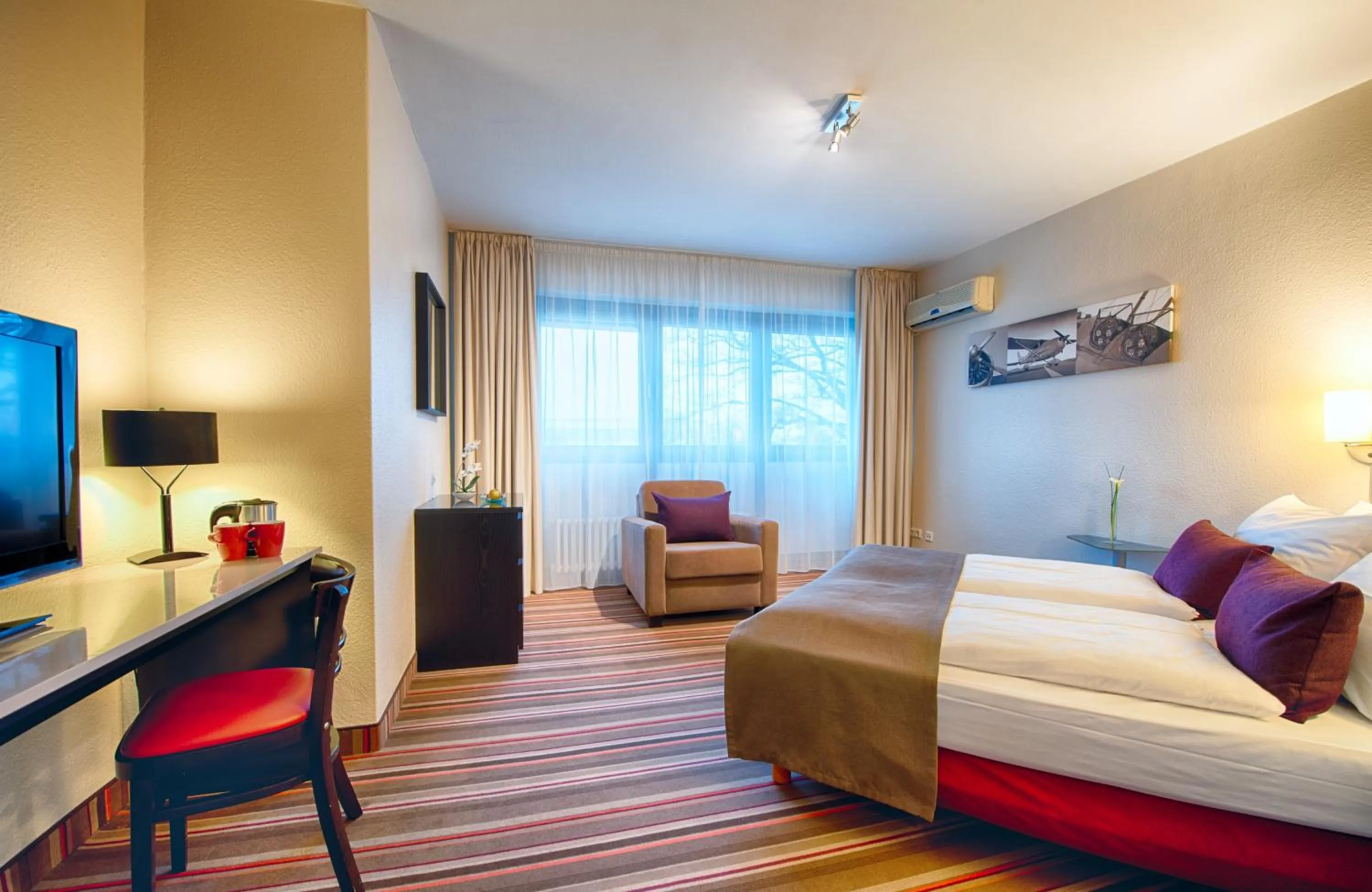 Bedroom, TV/Entertainment Center in Leonardo Inn Hotel Hamburg Airport