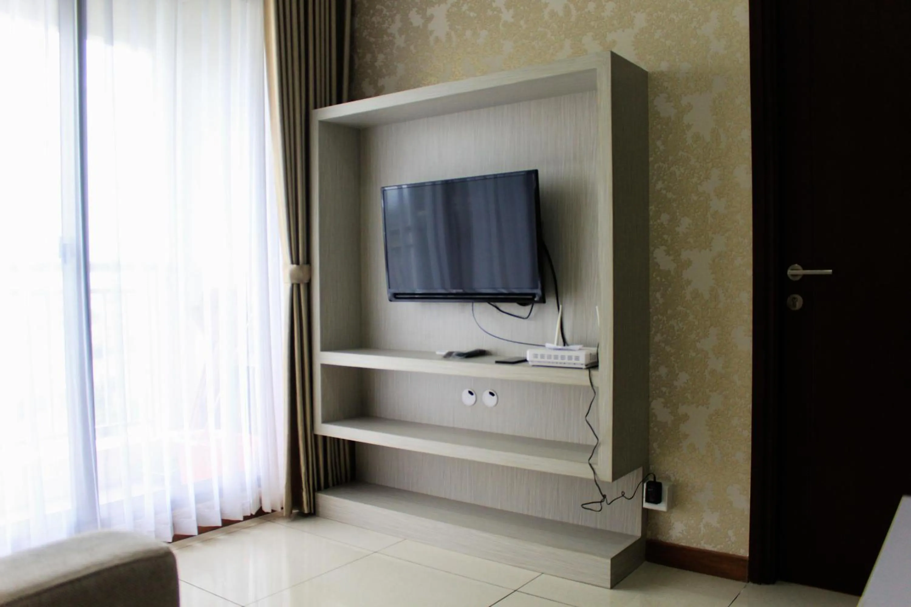 TV and multimedia in Minimalist 1BR Apartment at M-Town Signature By Travelio