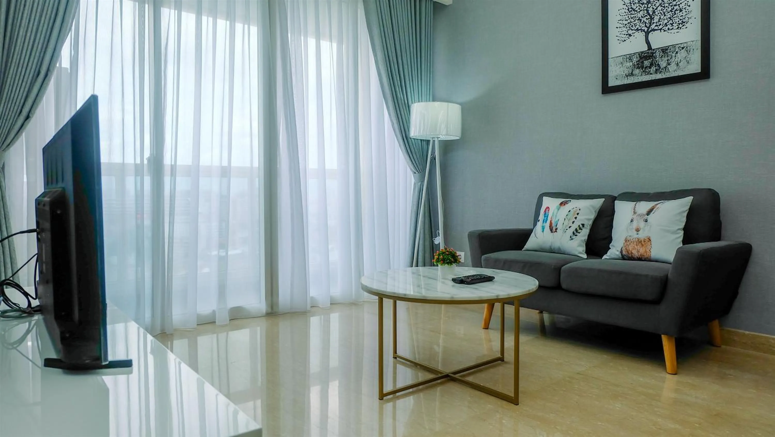 Living room in Classy 2BR Apartment at Menteng Park with City View By Travelio
