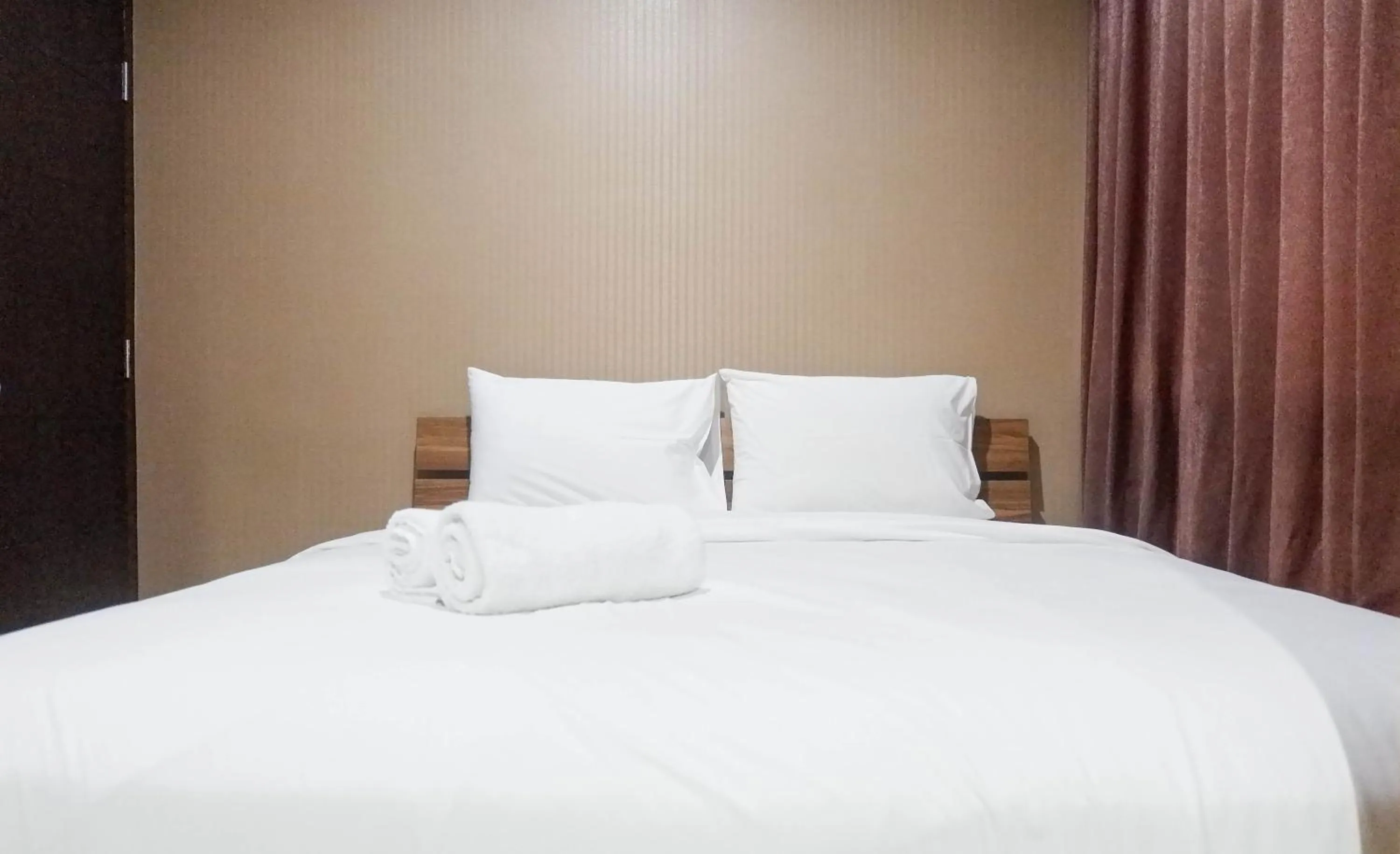 Bed in Minimalist 2BR Apartment at Tamansari Papilio By Travelio